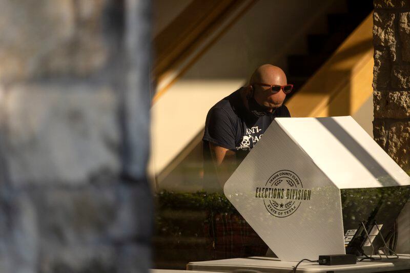 A man stands in front of voting machines