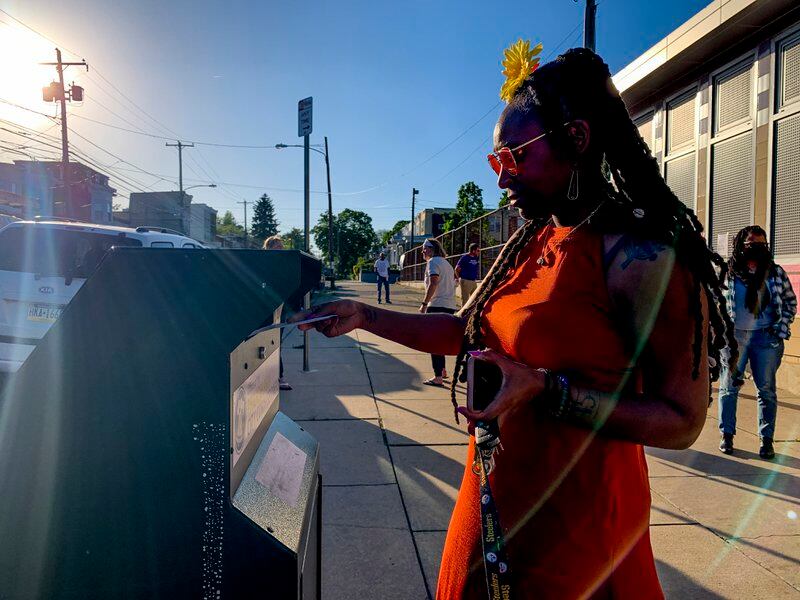 A Black woman drops off her mail ballot in a drop box in Philadelphia in the 2022 election.