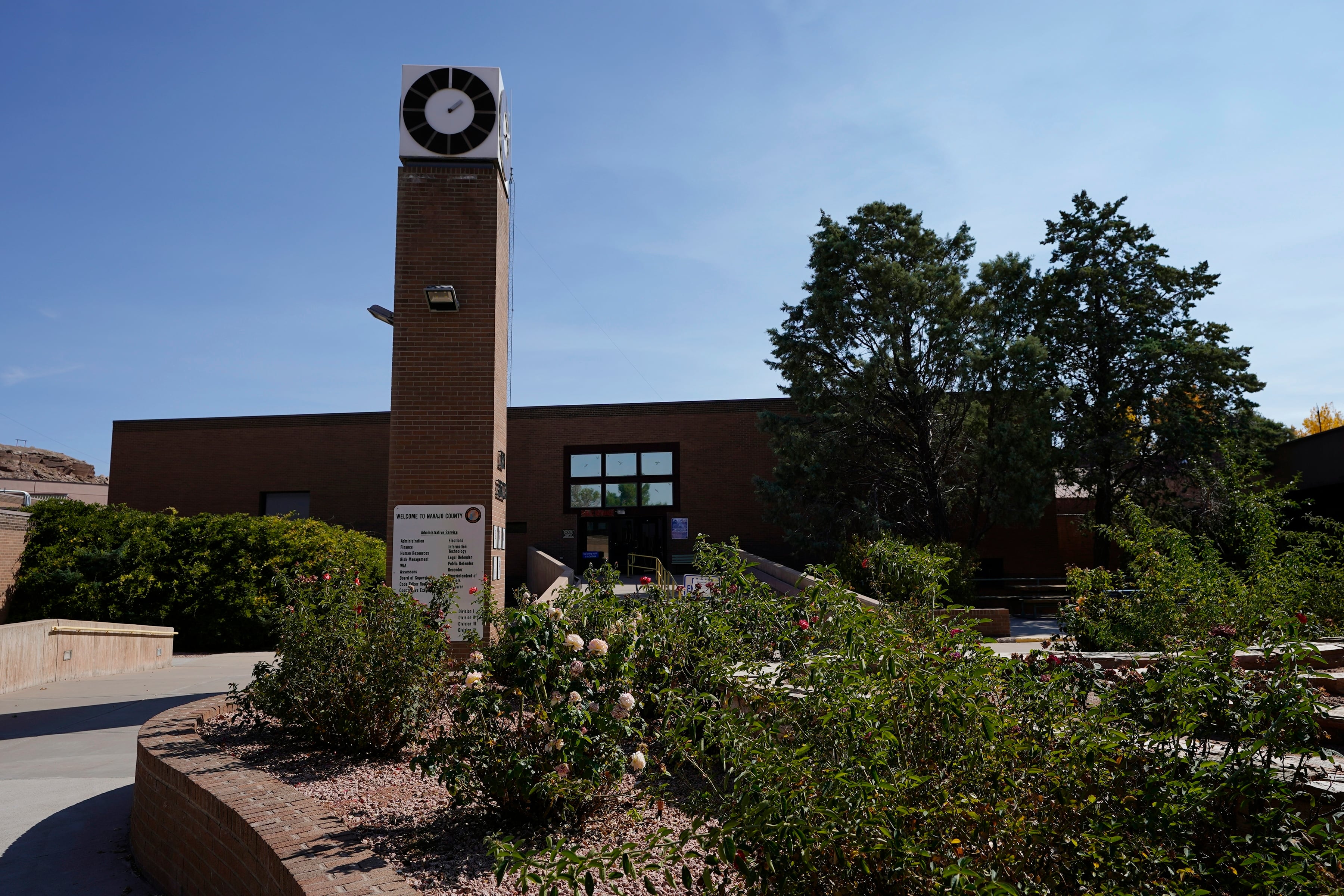 A brick building with flowers in the front courtyard.