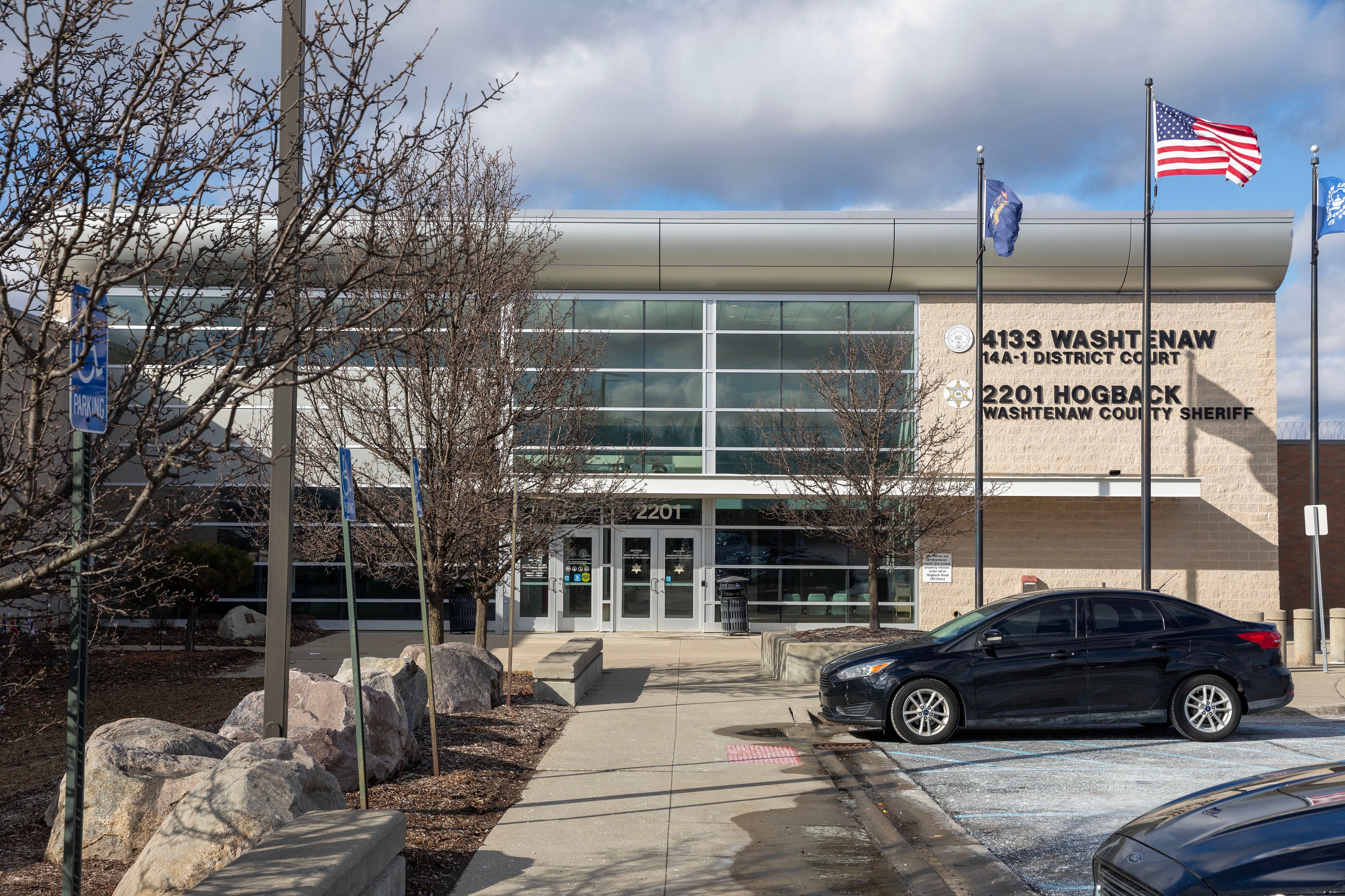 The outside of a large court house building on a partly cloudy day with some blue sky in the background.