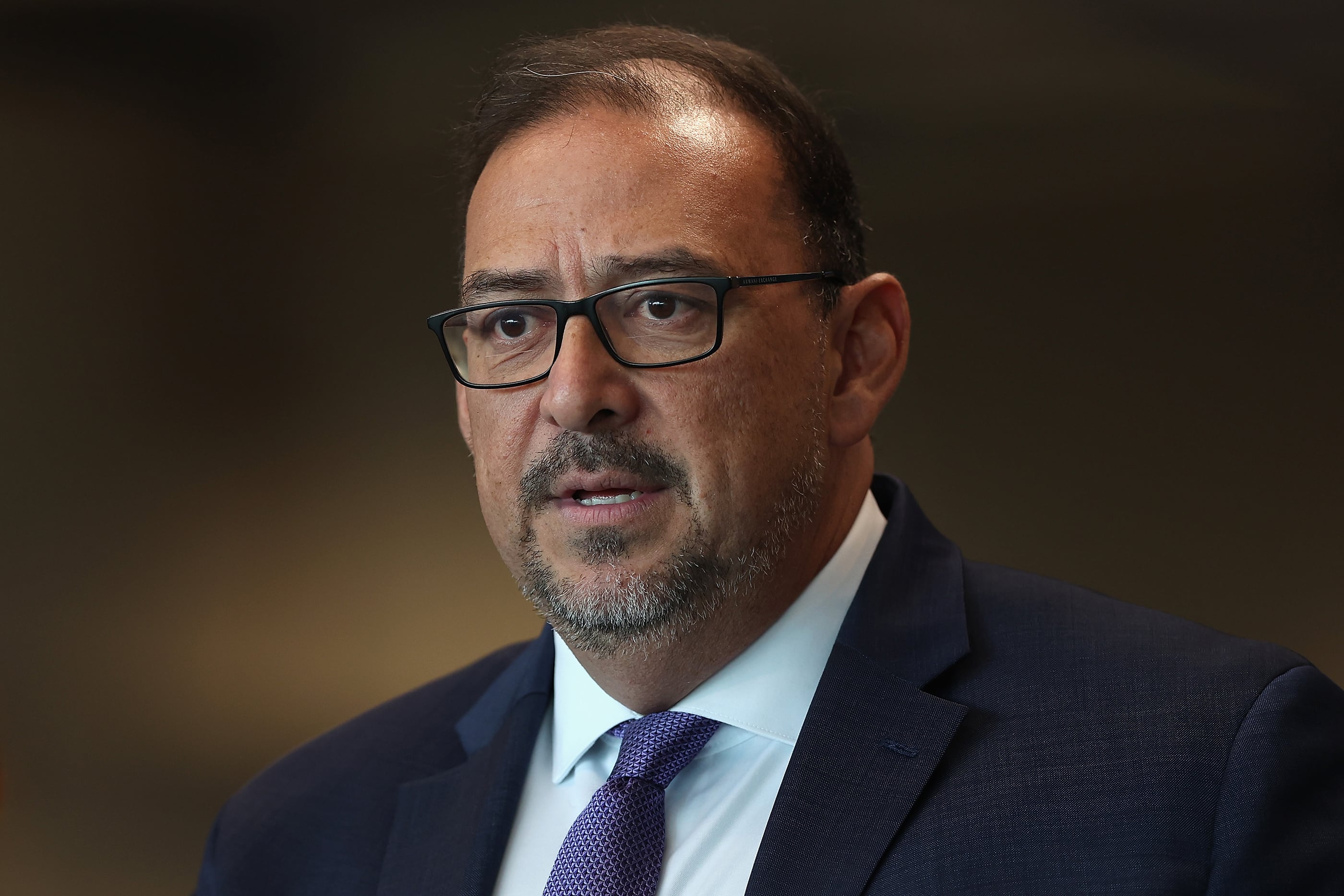 An up-close image of Arizona Secretary Of State Adrian Fontes in a suit speaking during a press conference.