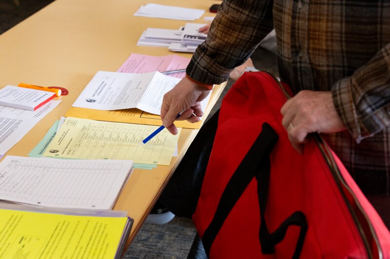 A poll worker at a Madison voting site points to new paperwork that election officials follow and fill out to ensure no ballots go missing.
