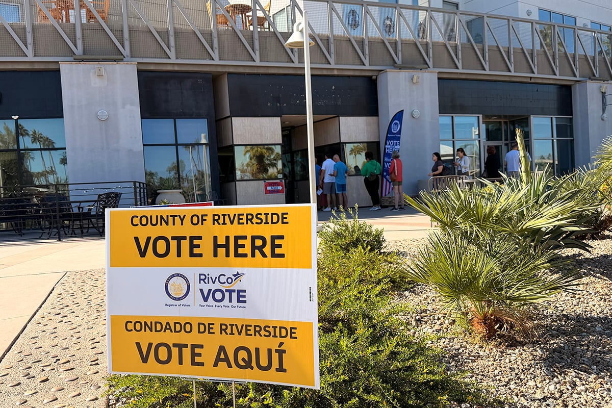 A yellow-and-white sign sits in front of a building.