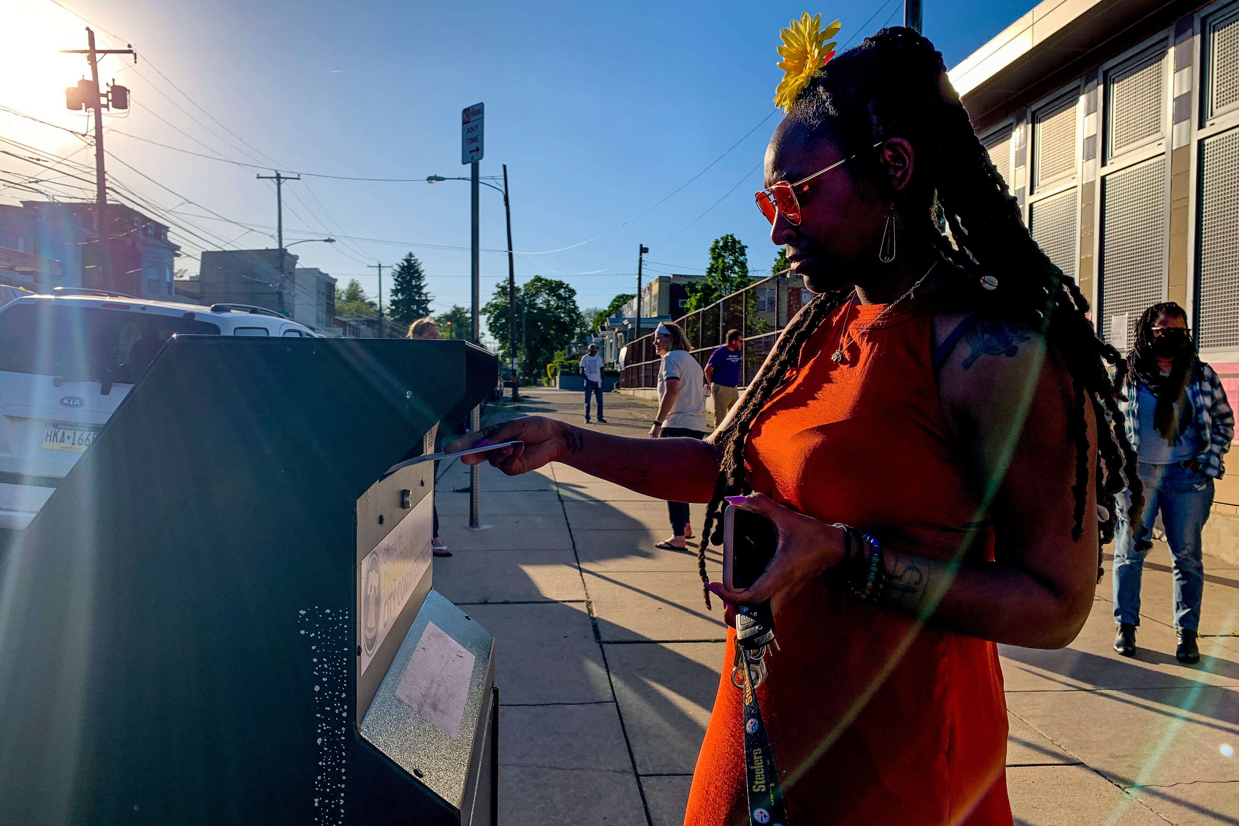 A Black woman drops off her mail ballot in a drop box in Philadelphia in the 2022 election.
