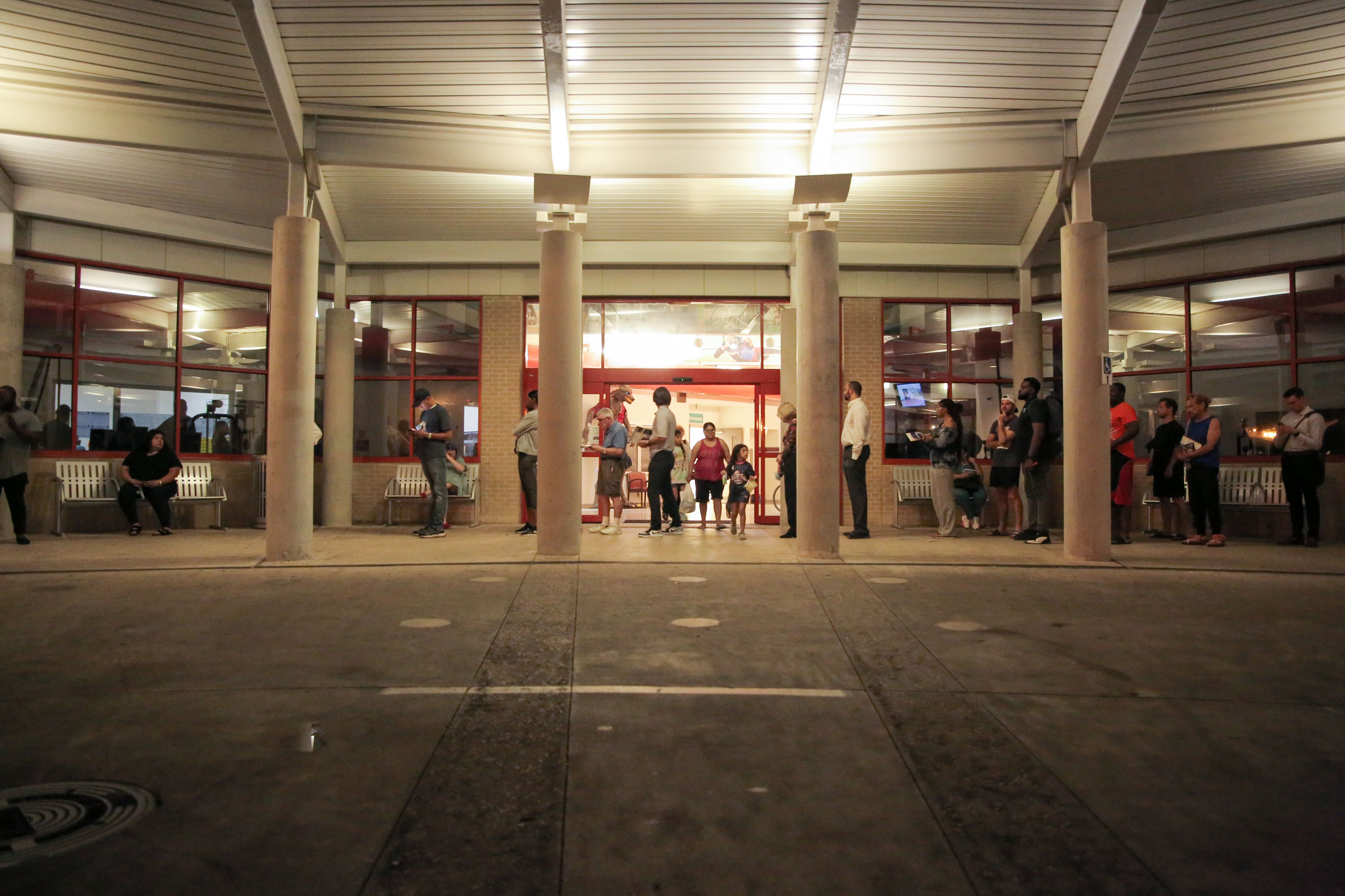 A crowd of people stand outside of a building