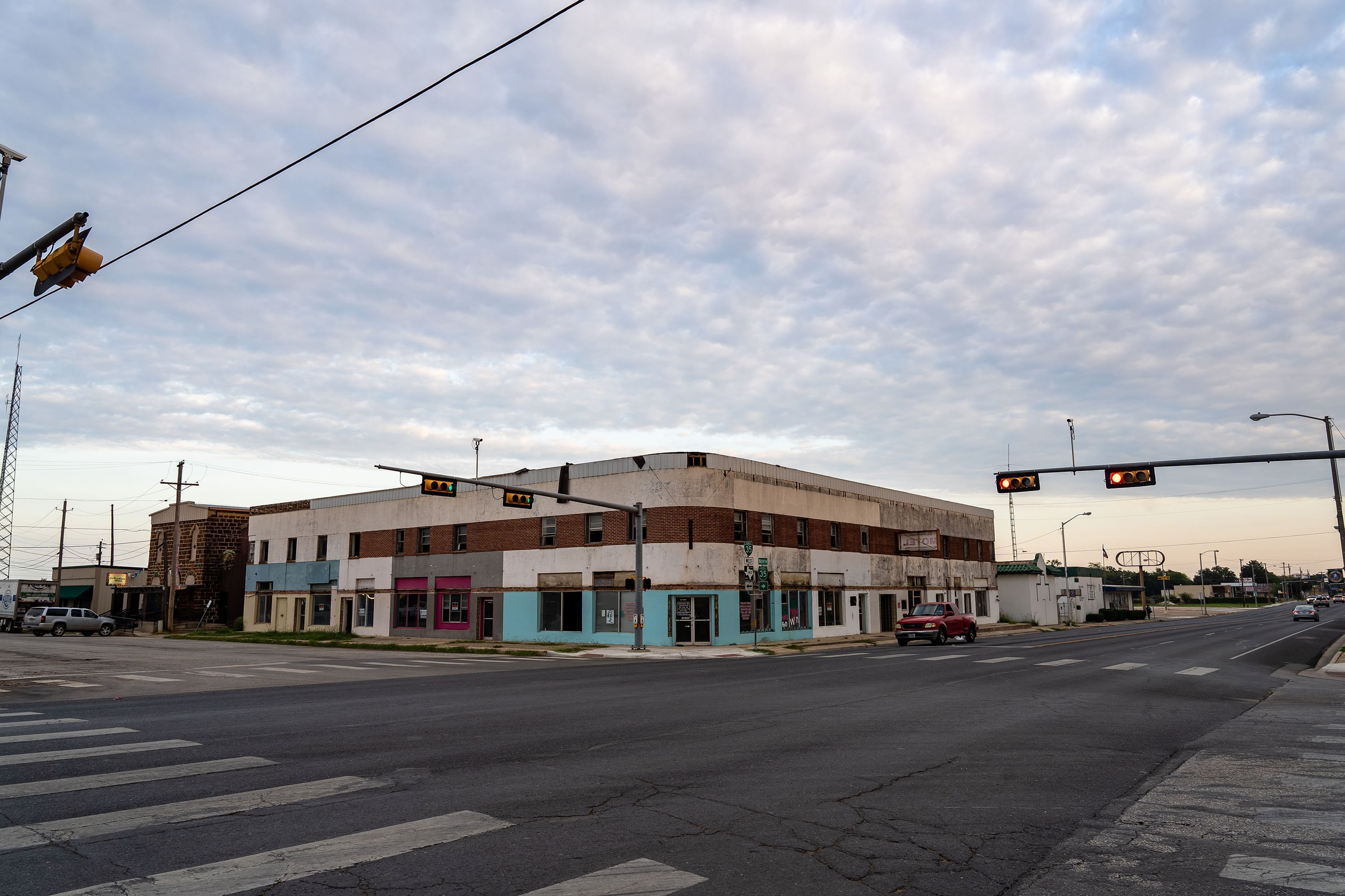 A view of a small town block with a big cloudy sky.