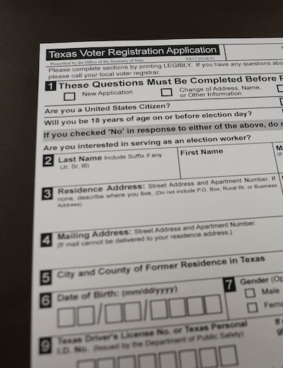 A blank voter registration form on a black table.