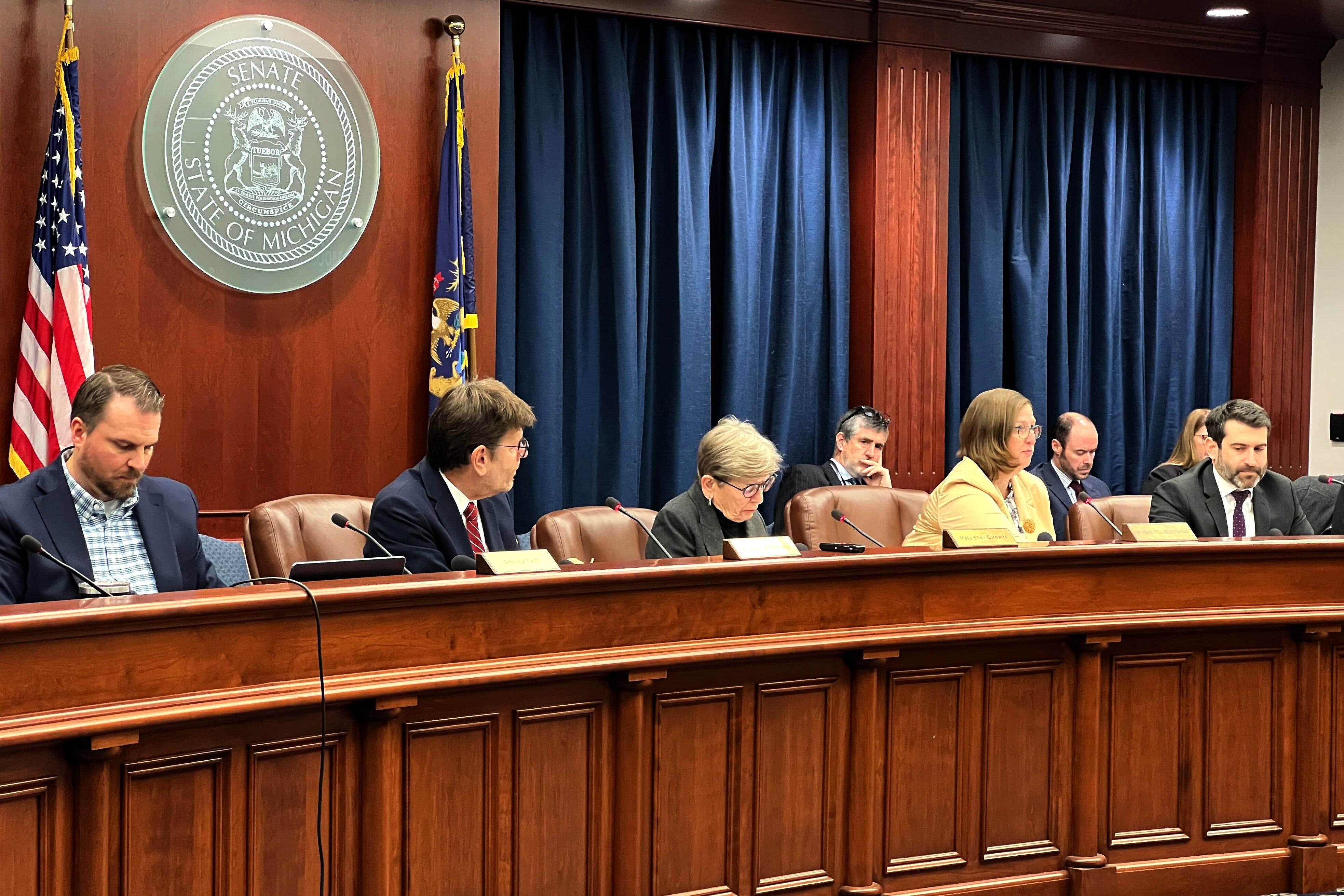A panel of people sit at the front of a room.