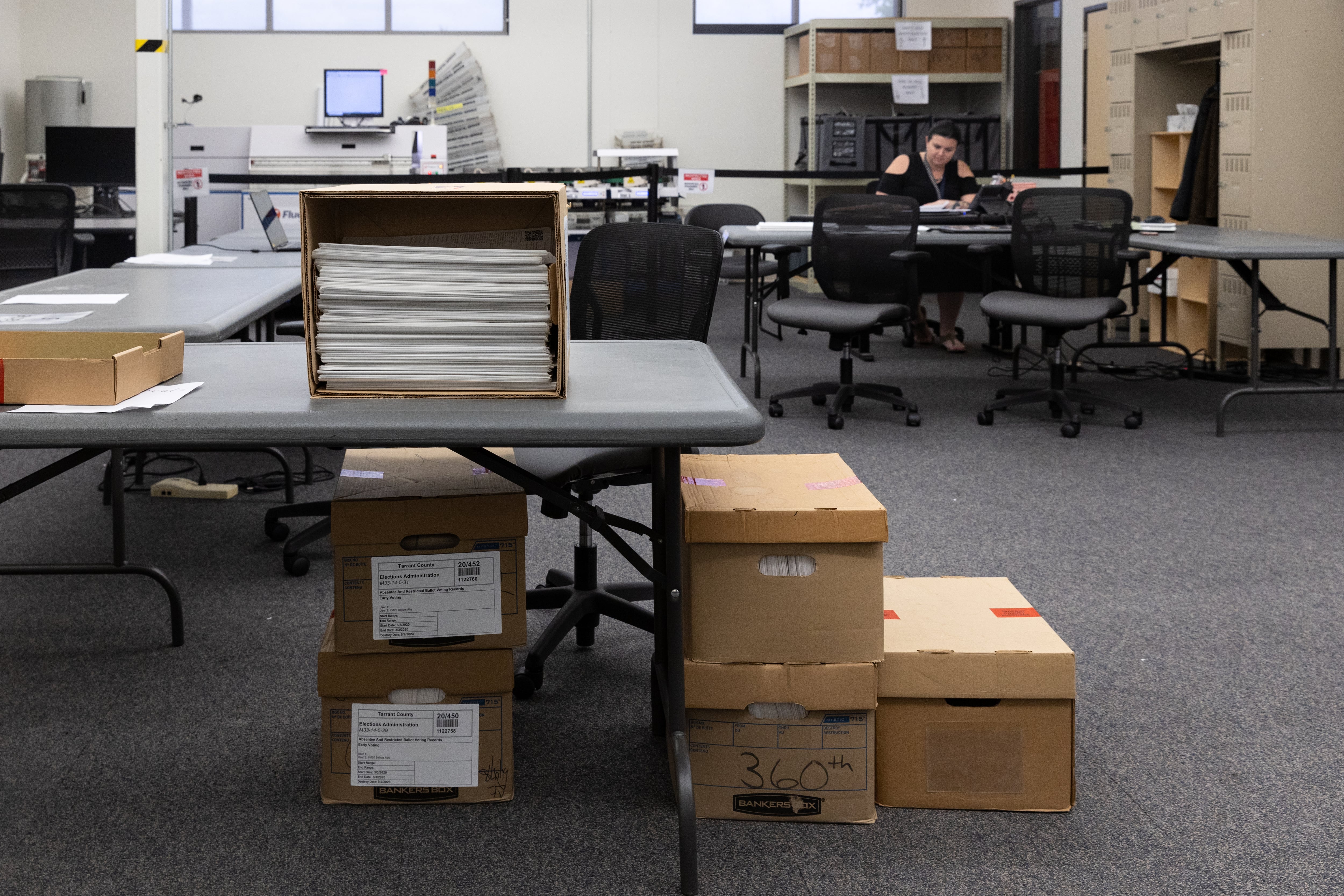 A pile of boxes and stacks of paper in an office