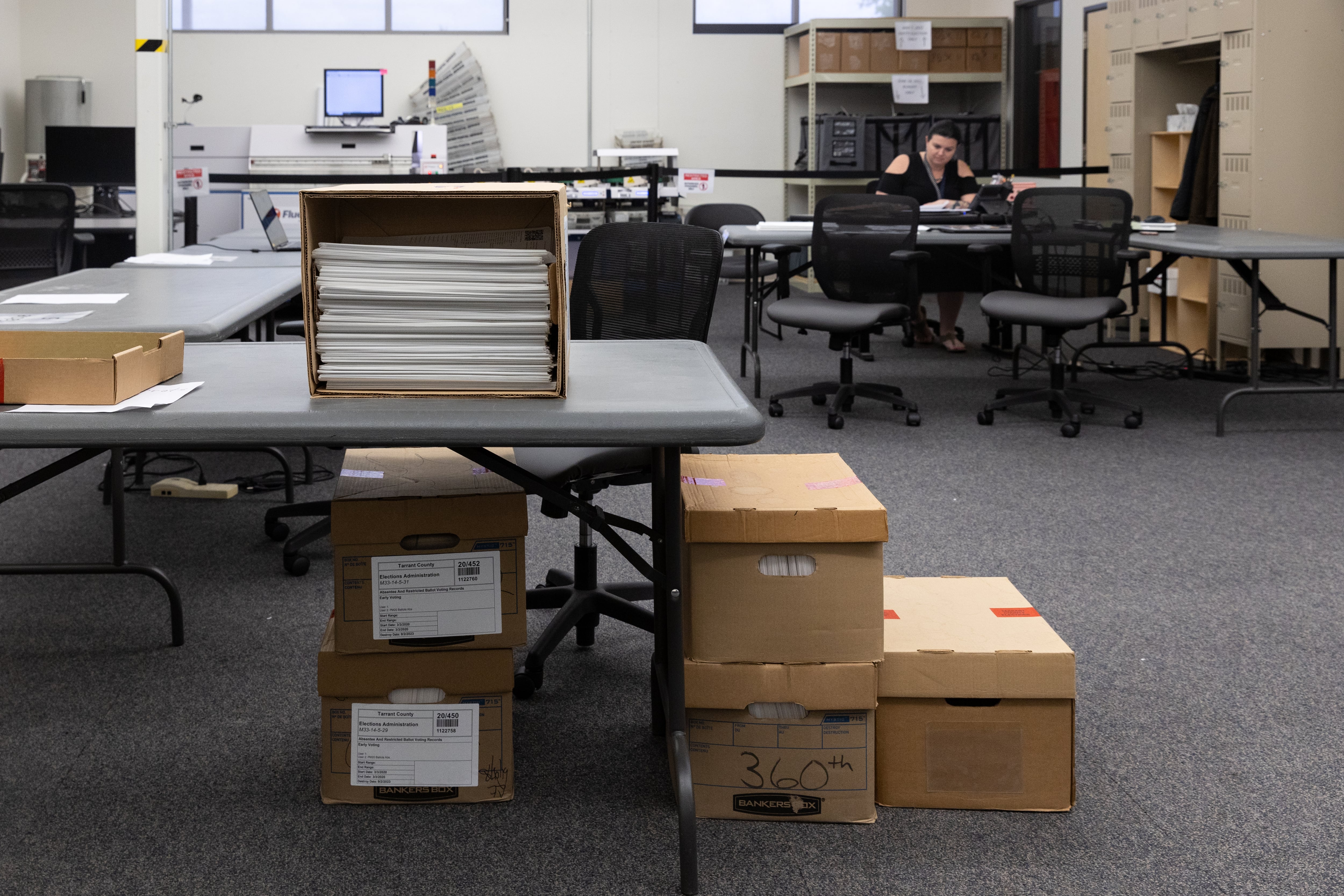 A pile of boxes and stacks of paper in an office