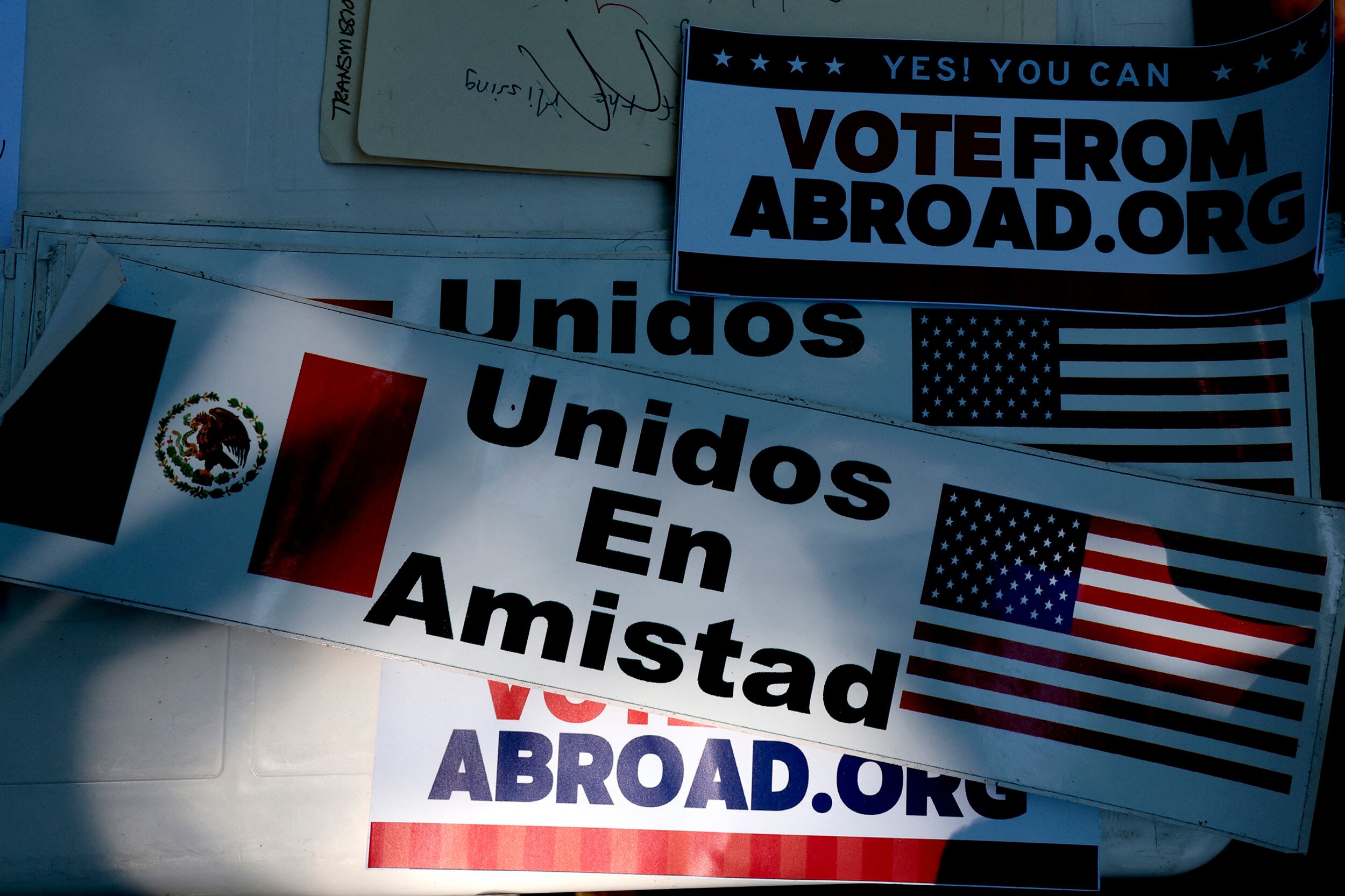 A photograph of some stickers and posters in English and Spanish.