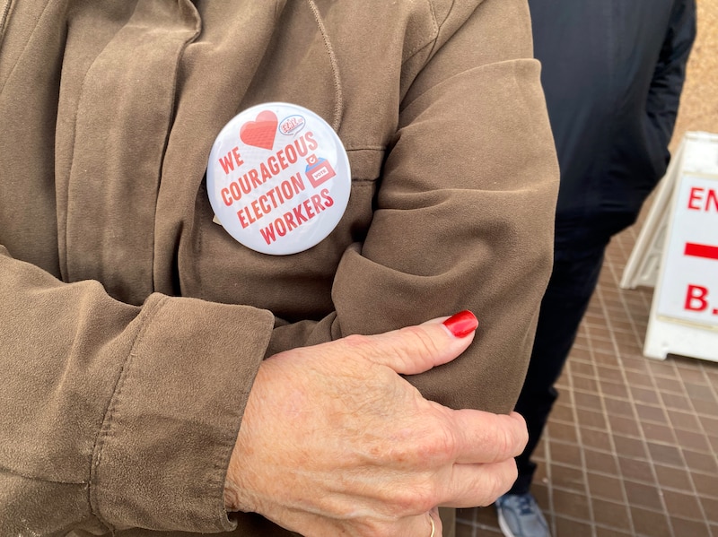 A photograph of a person's pin attached to their coat.