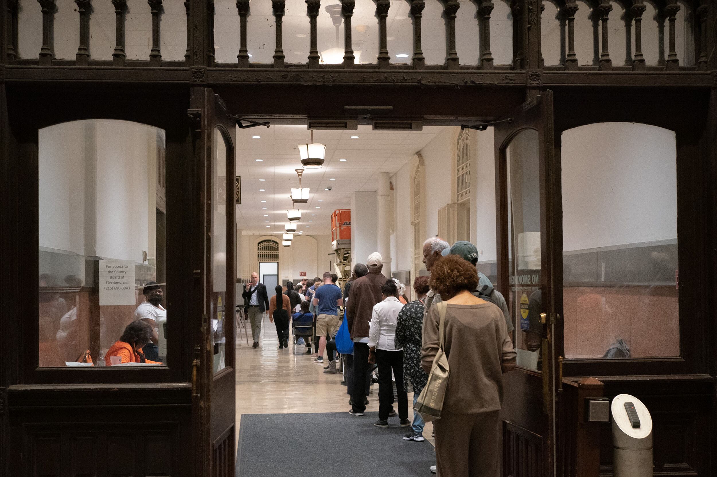 A line of people wait to vote inside of a building.