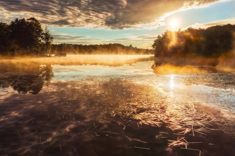 The sun rises on a scenic lake.