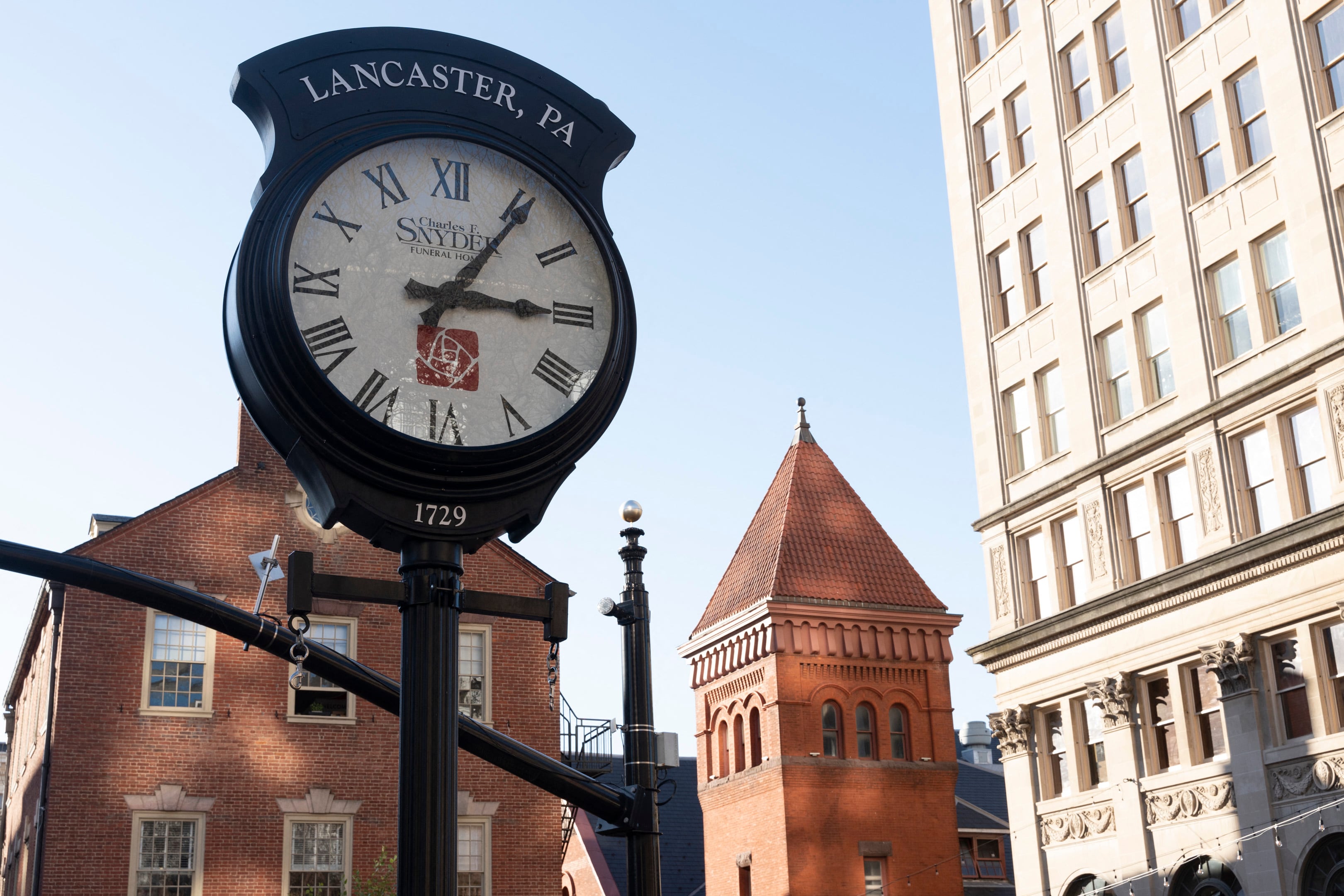 A large clock and a building in the background.