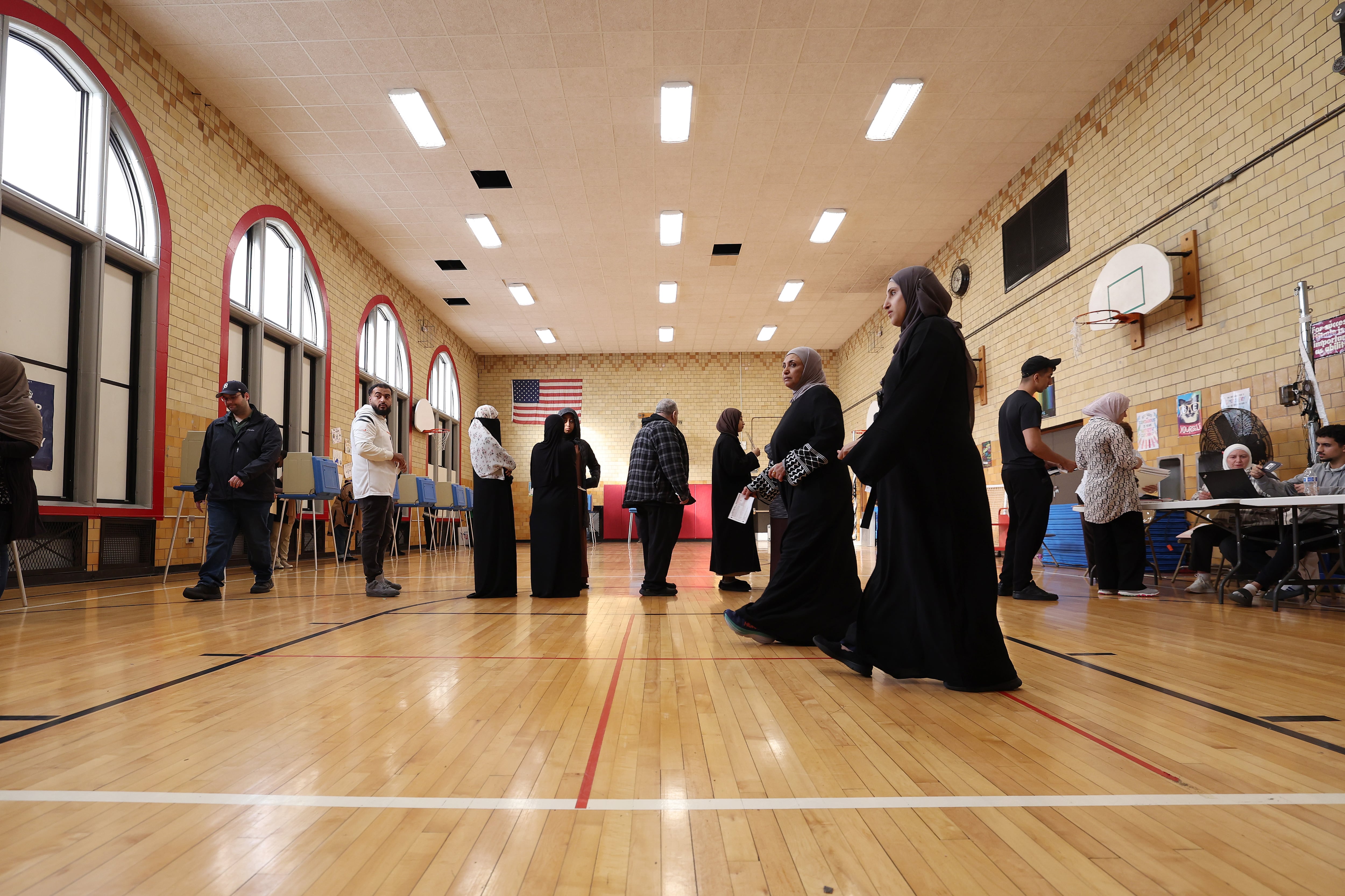 People line up in a school gymnasium.
