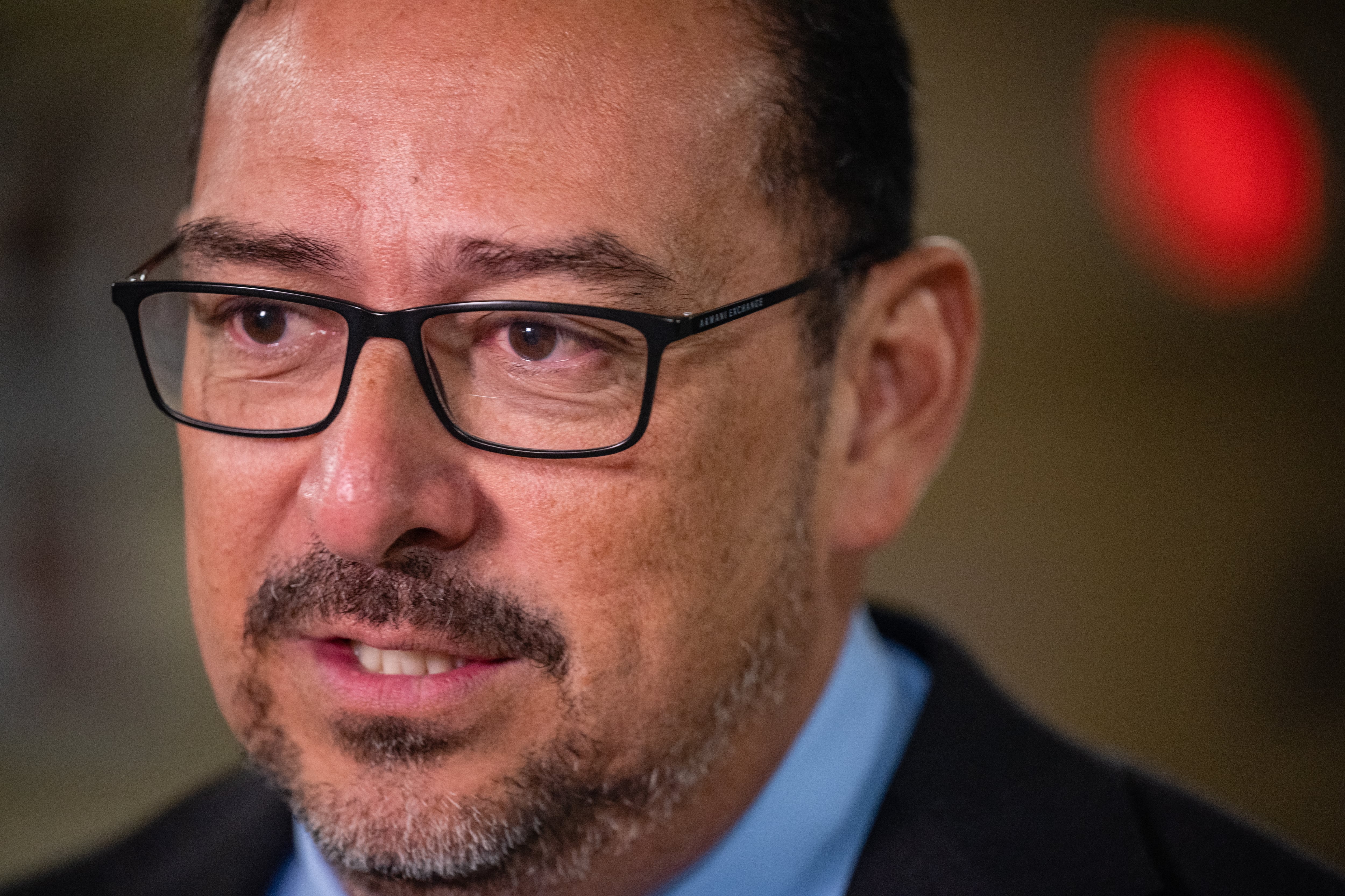 A tight headshot of a man with glasses