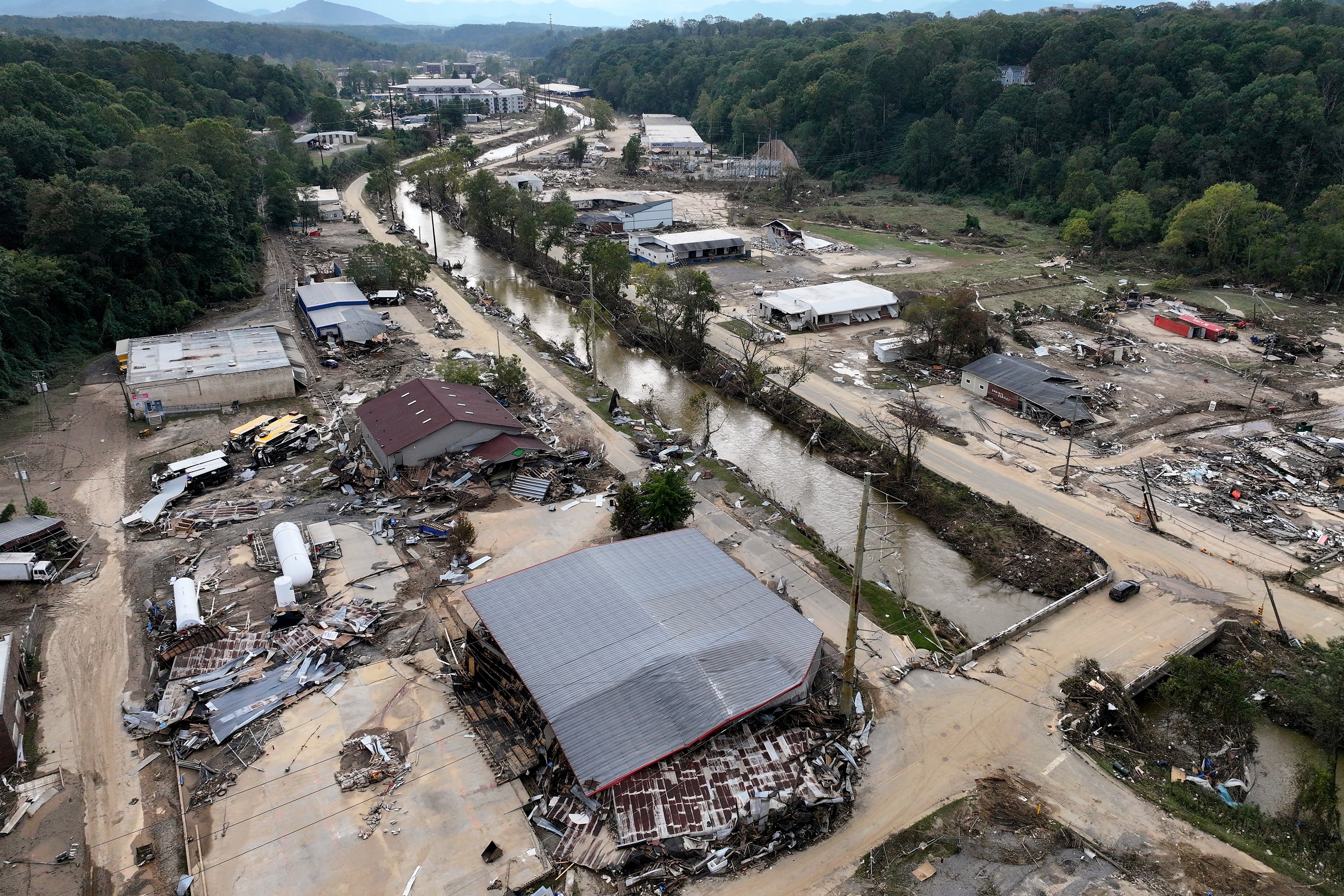 An aerial view of flood damage to a town with a river running in the middle.