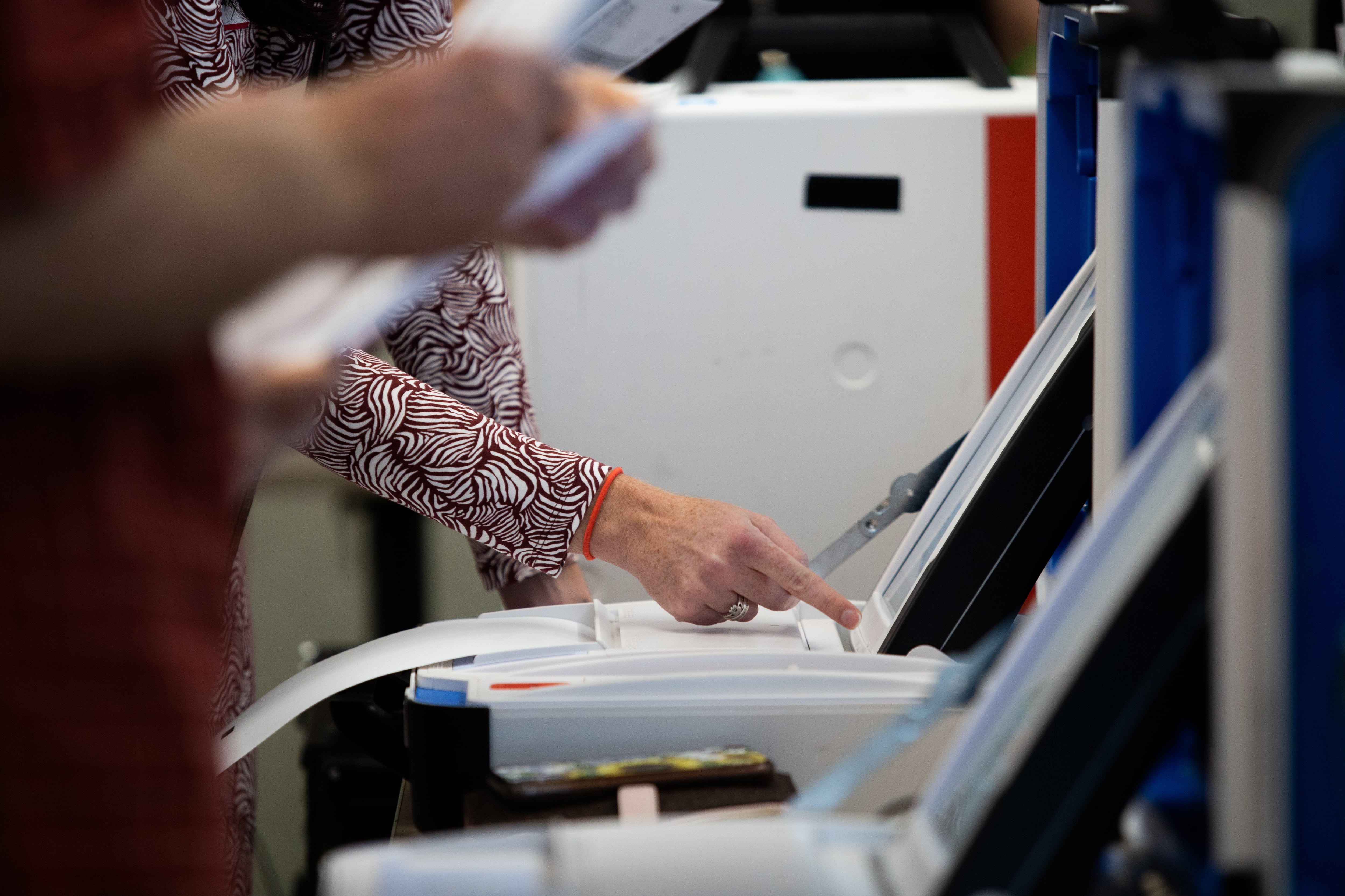 A hand points at a computer screen.