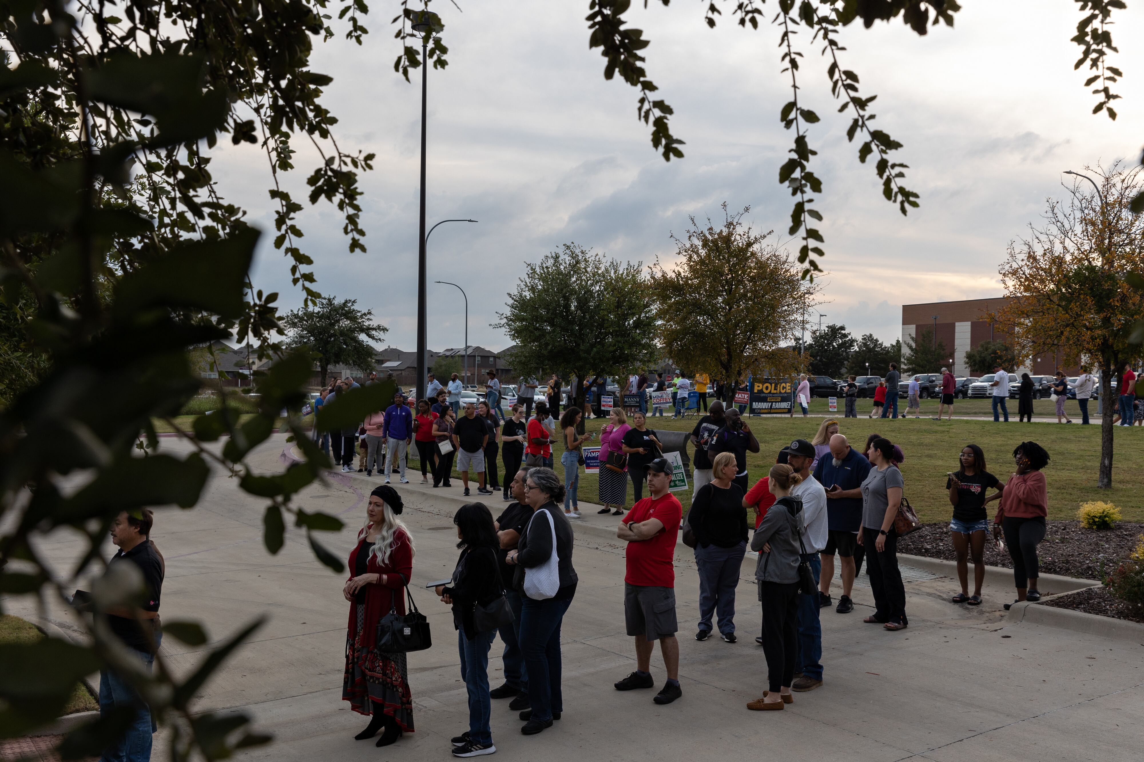 A long line of people wraps around a parking lot