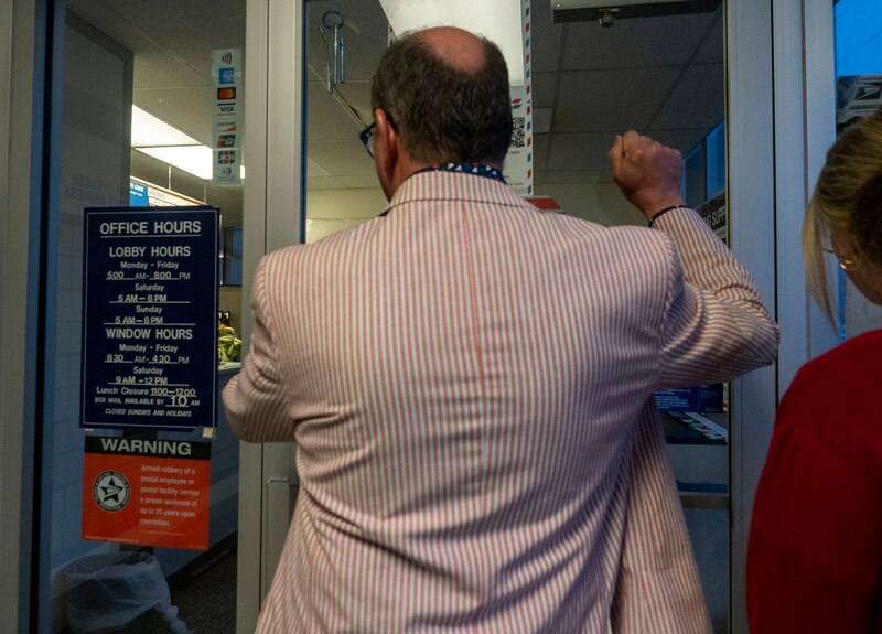 a man wearing a red and white striped suit knocks on a door.