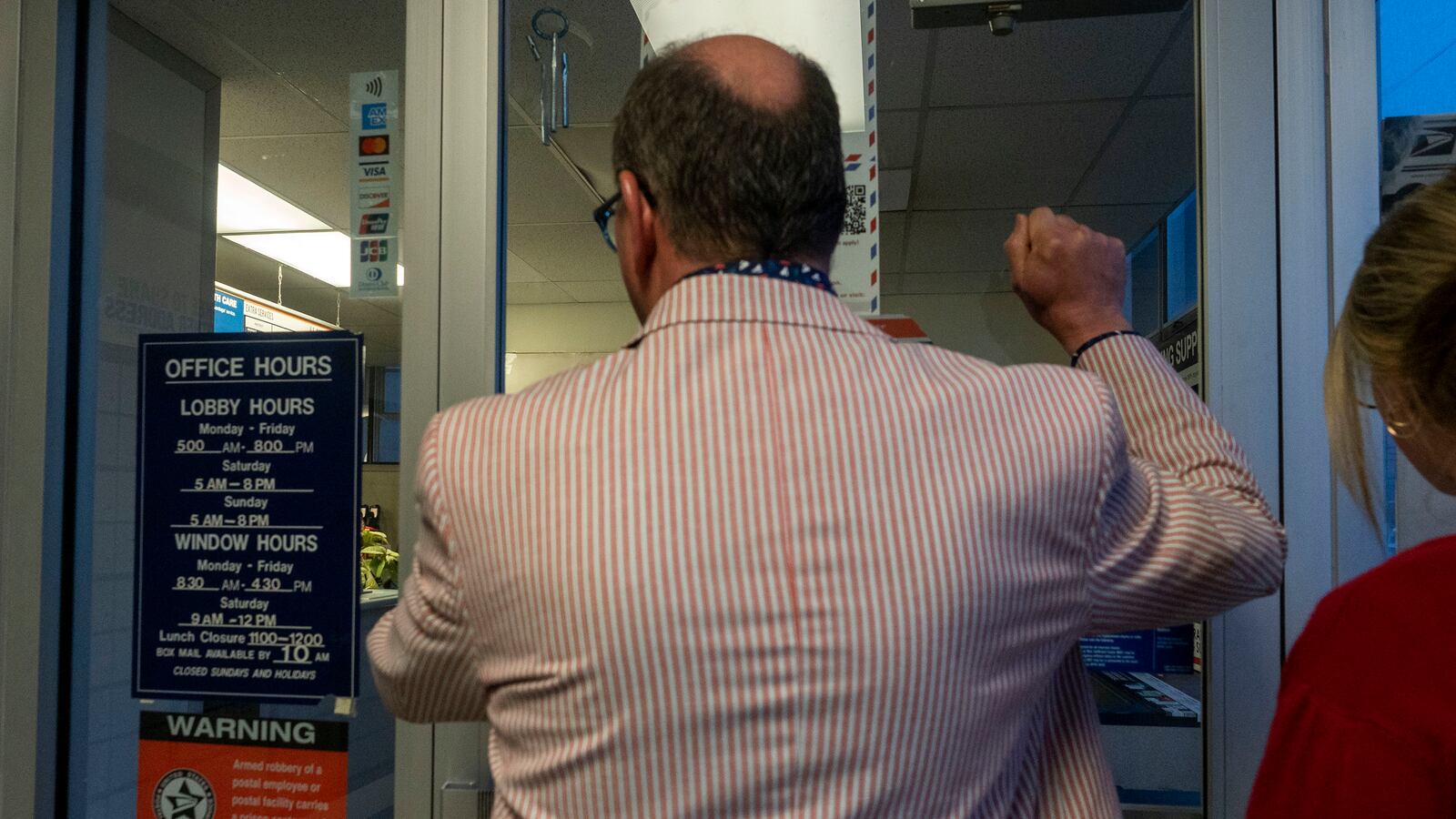 a man wearing a red and white striped suit knocks on a door.