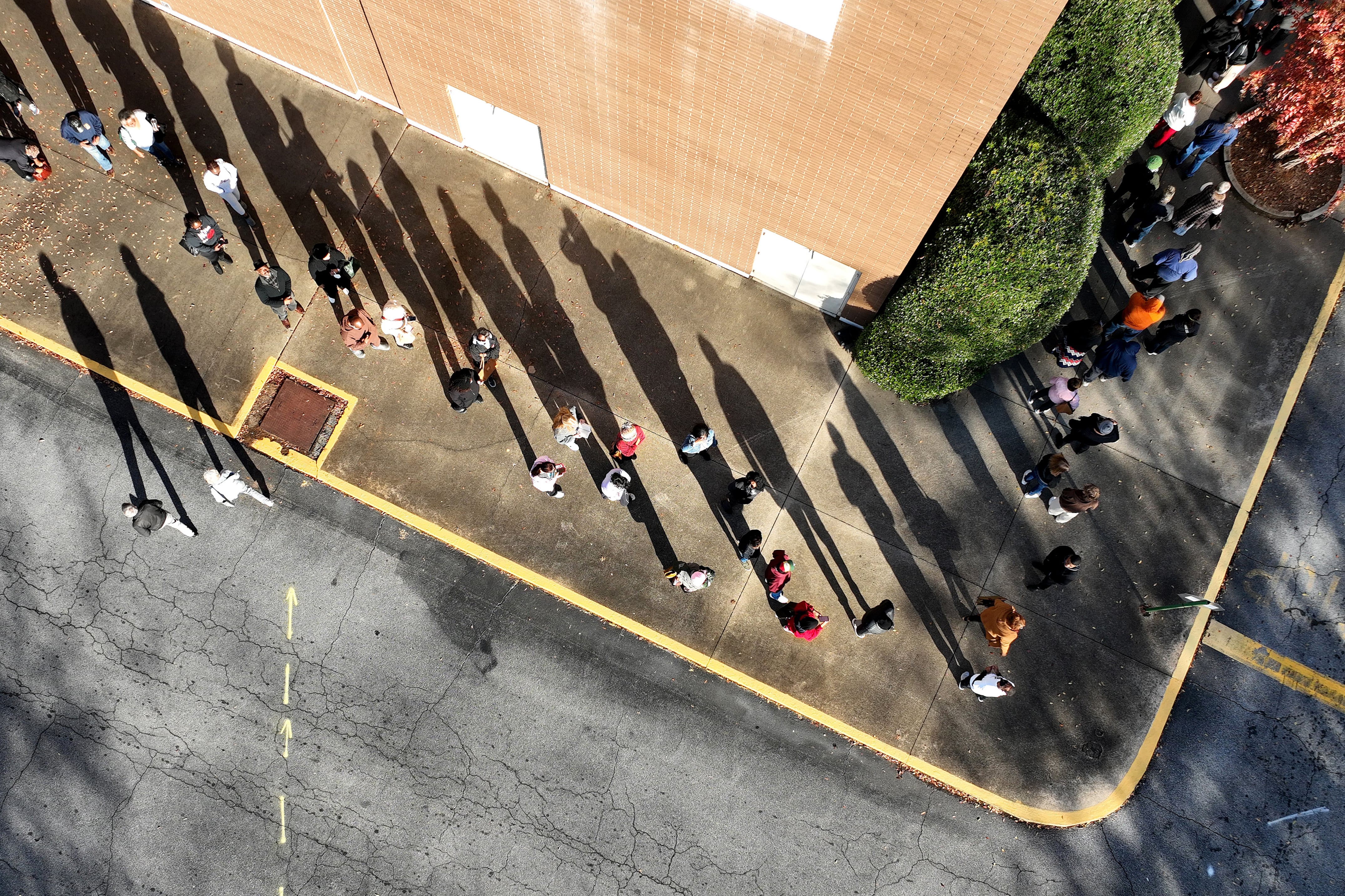 An aerial view of voters in line outside of a building.