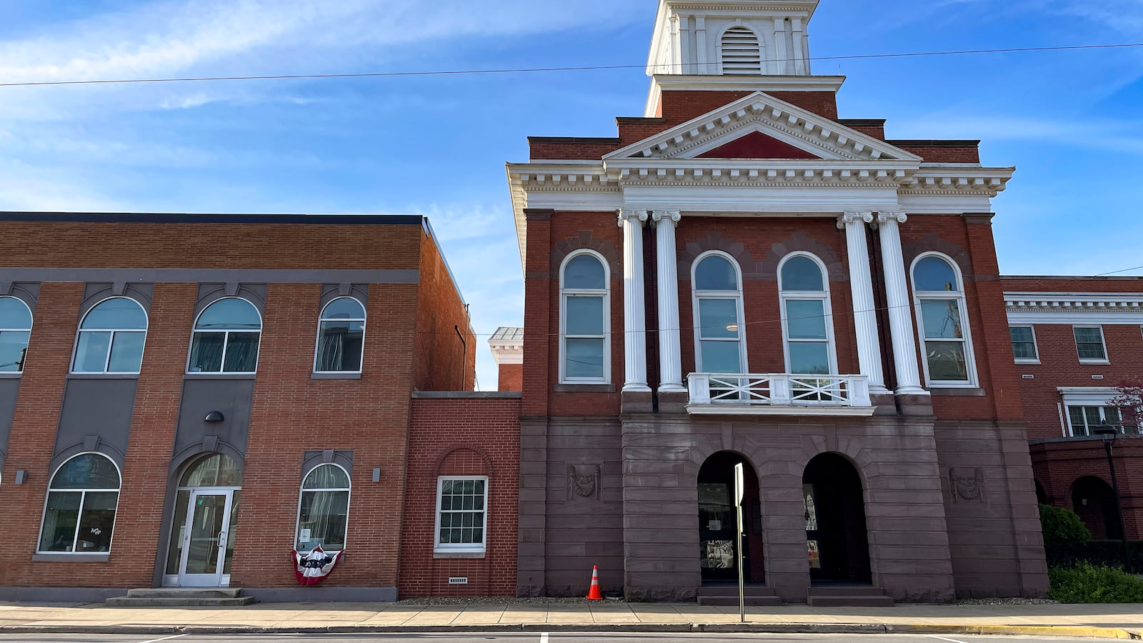 A large colonial style brick building with a blue sky in the background.