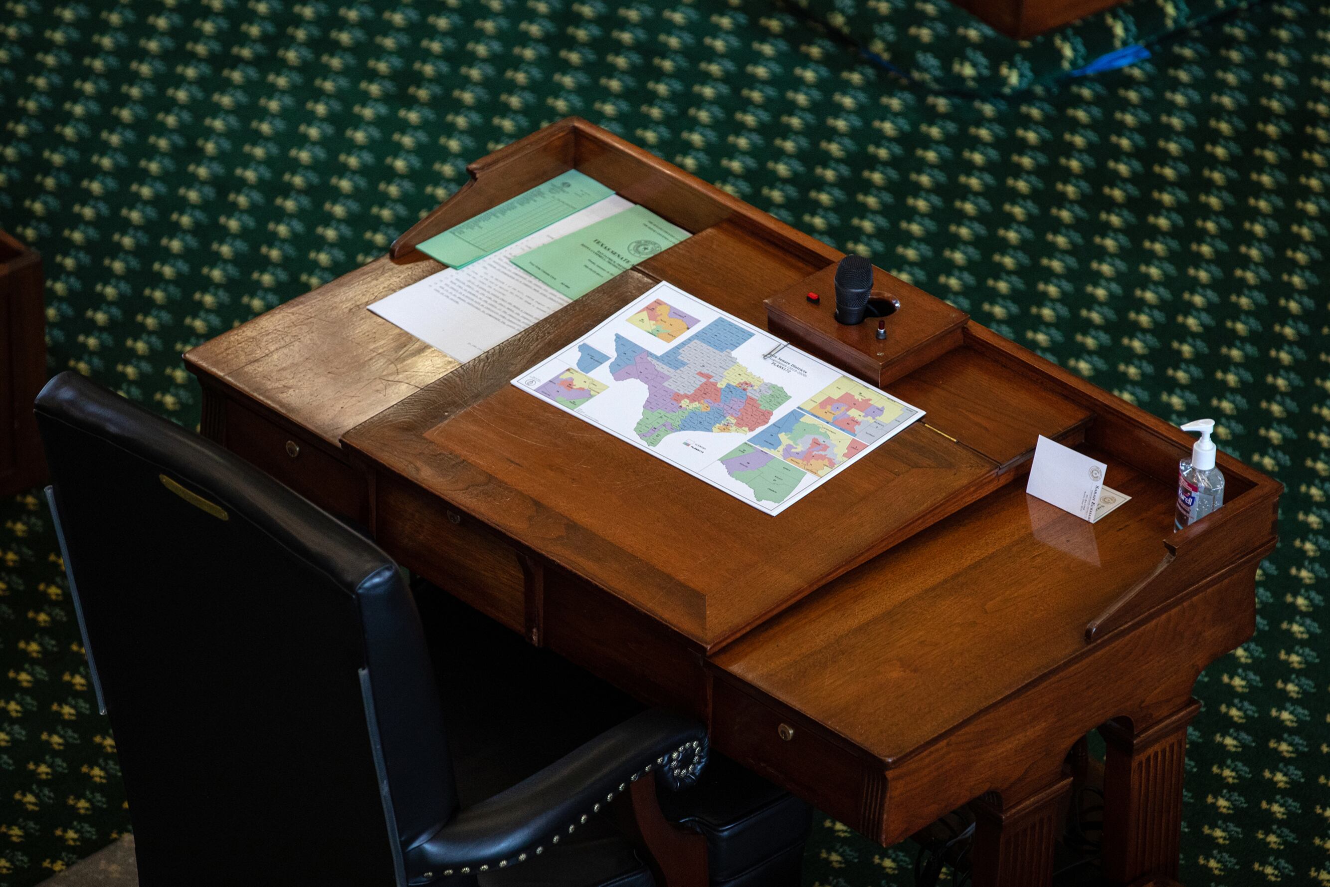 An aerial view of a wooden desk with a colorful map of Texas.