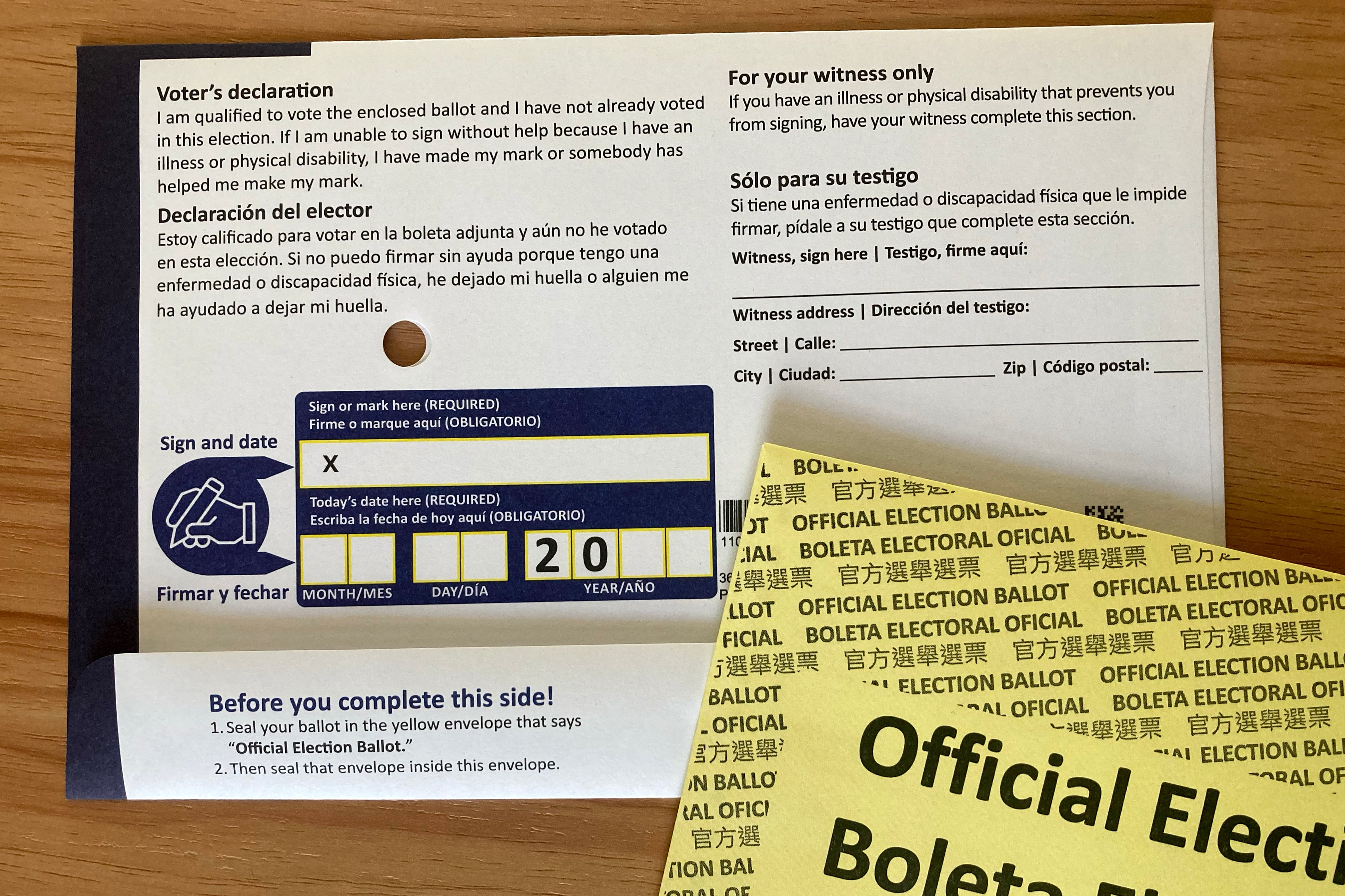 A white and blue mail in voting ballot on a wood table.