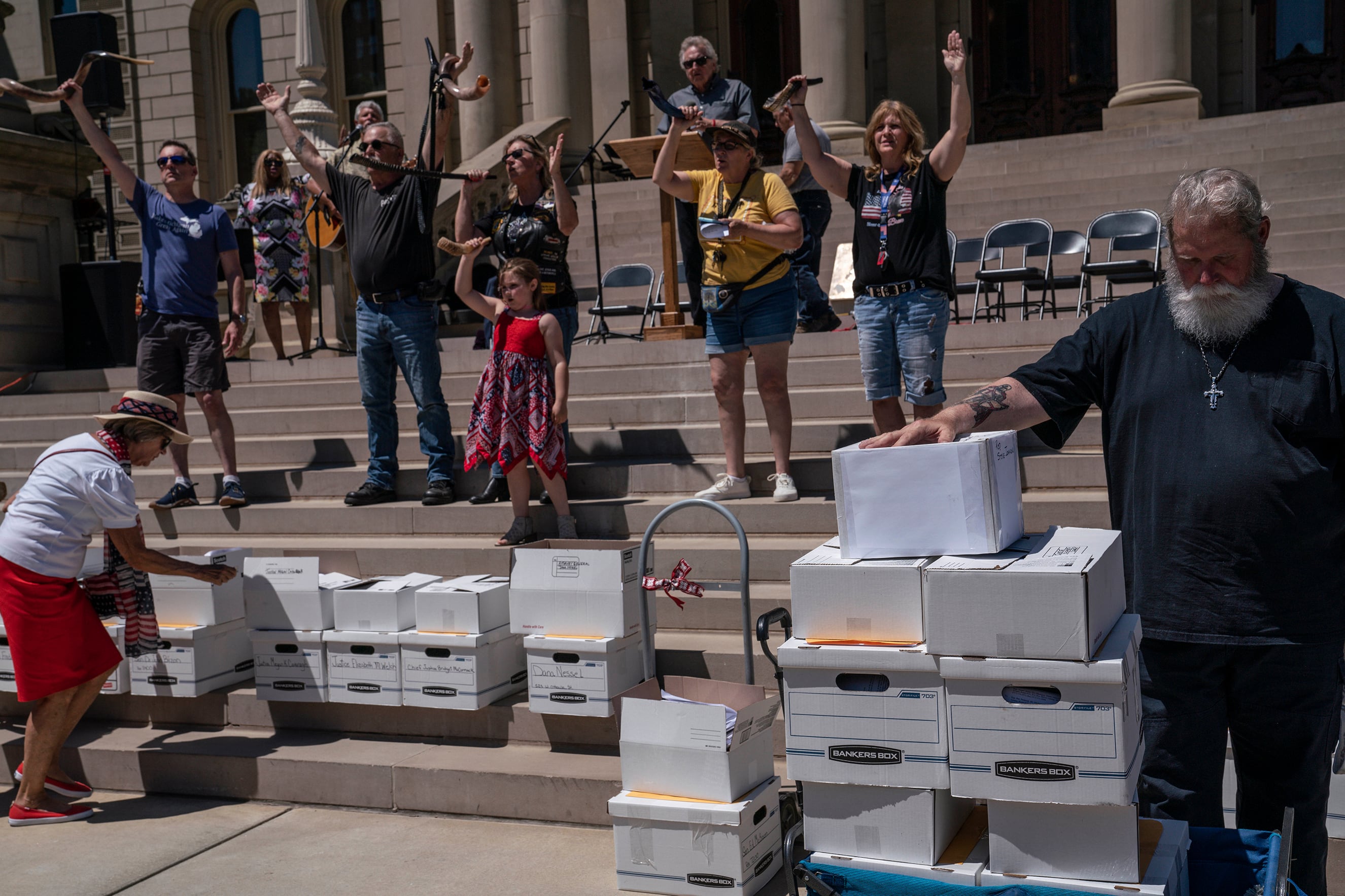A photograph of a group of people standing on a large set of stairs outside of the Michigan State Capitol building.