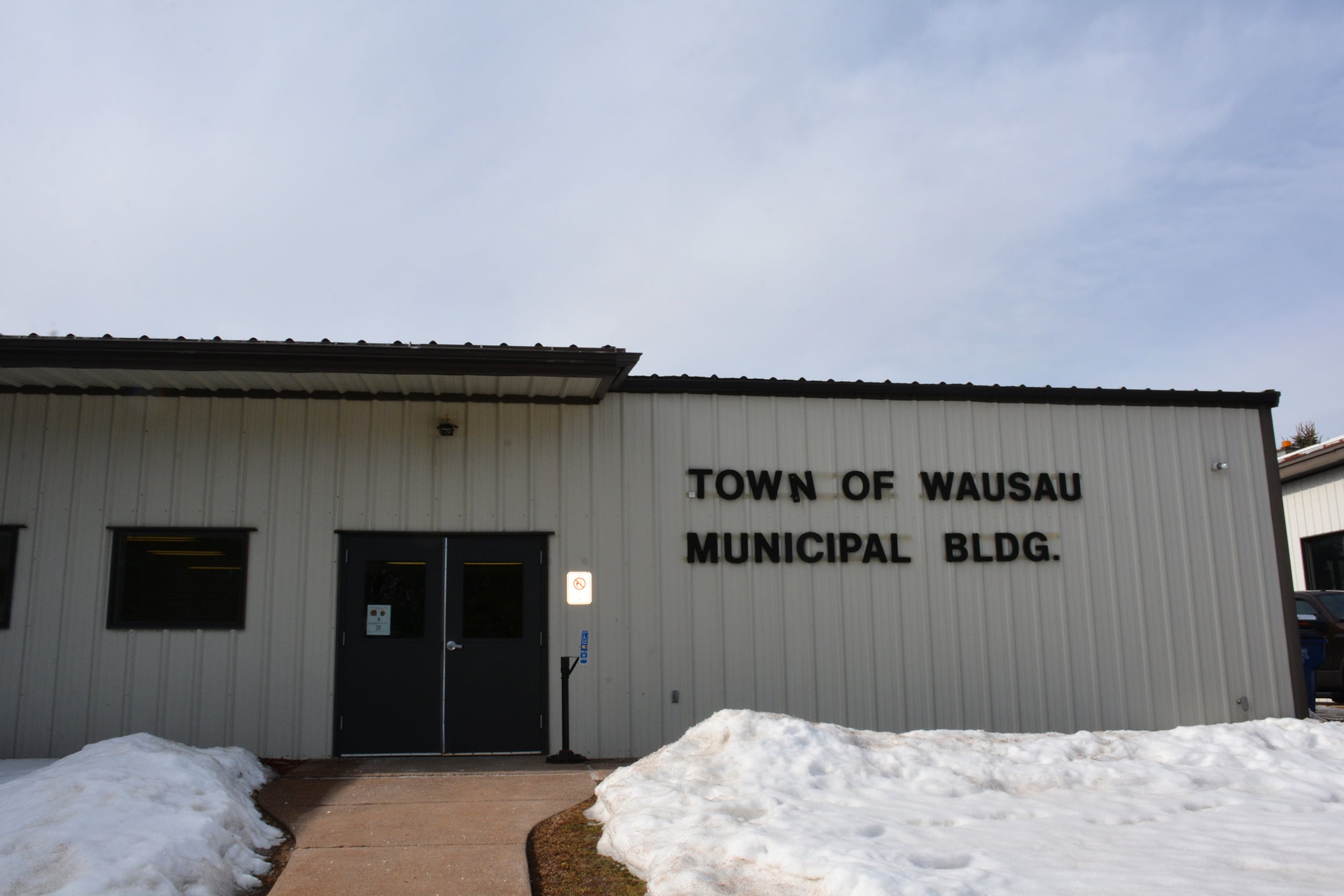 A photograph of a small building with snow around the front entrance.