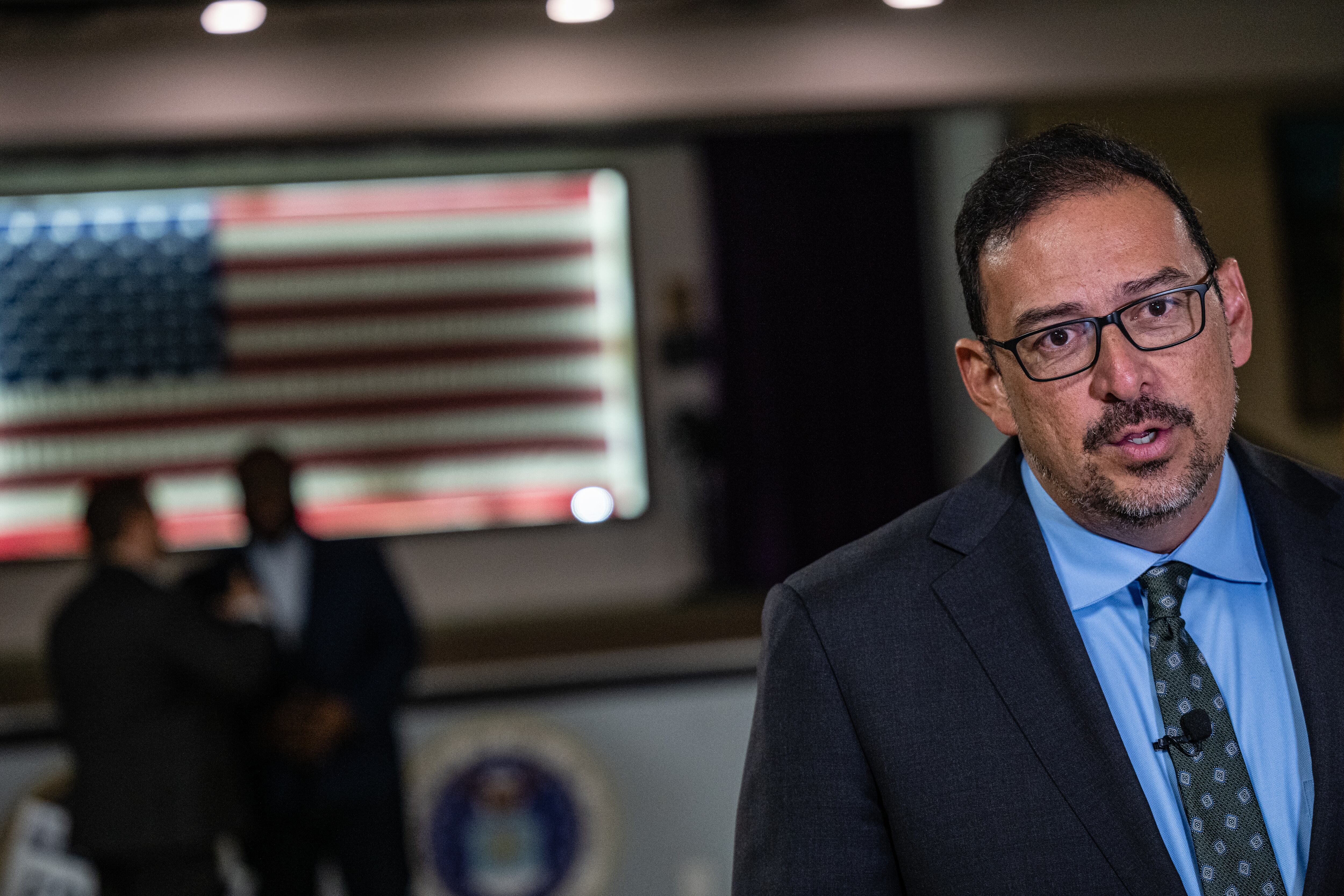 man in suit with blue shirt and tie does an interview