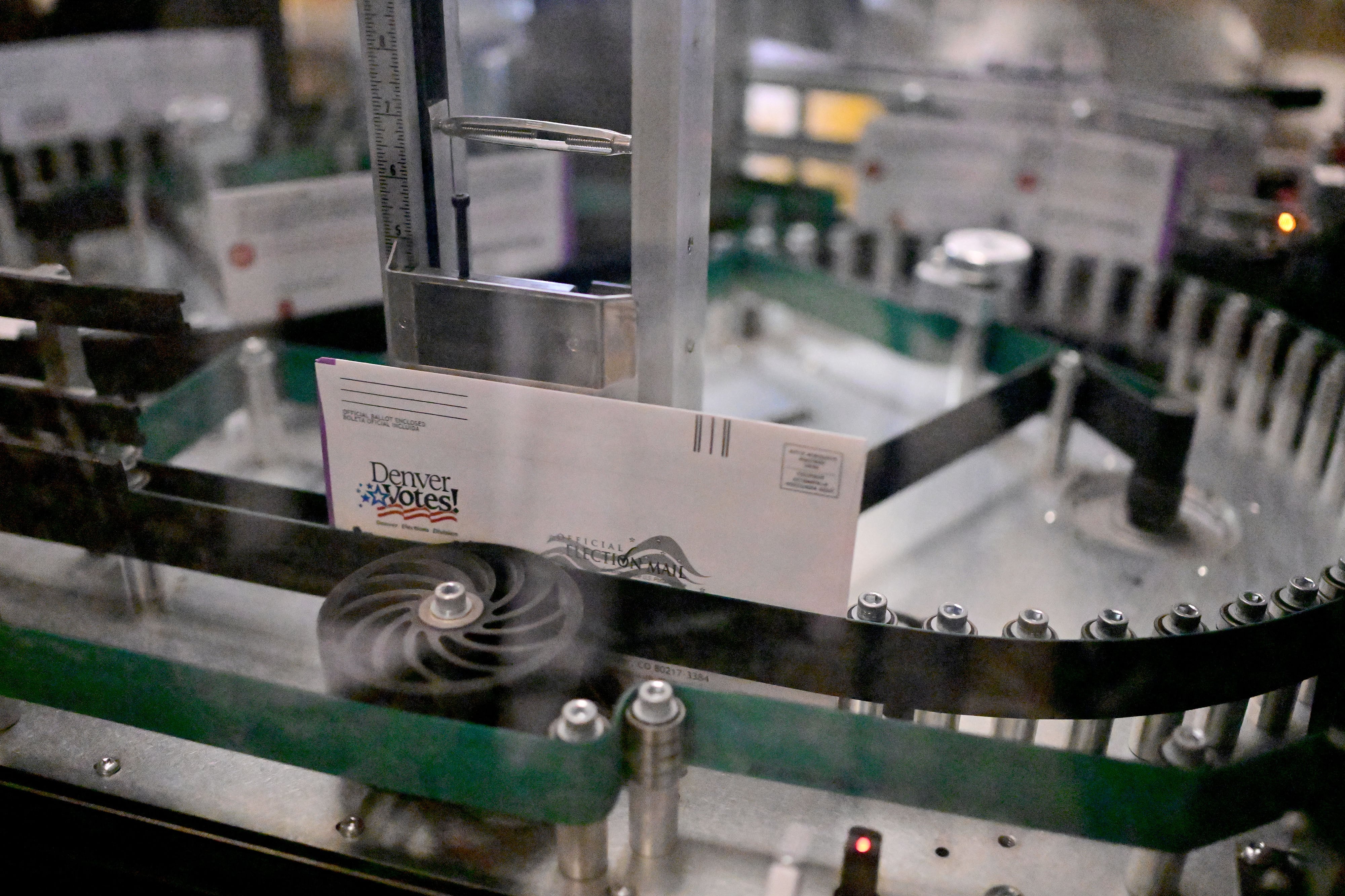 A singular mail in ballot goes through a sorting machine.