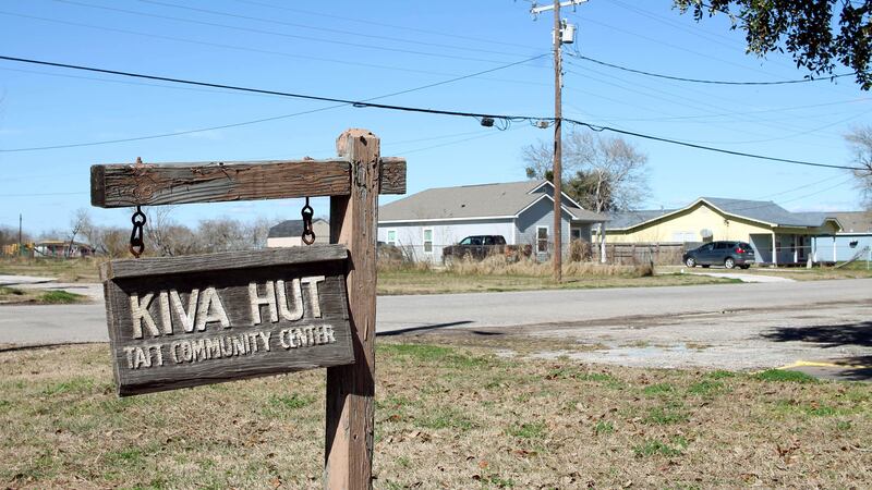 A wooden sign that says "Kiva Hut" and a telephone pole and a house in the background.