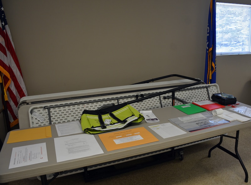 A photograph of a table with paperwork and other various items inside a small room.