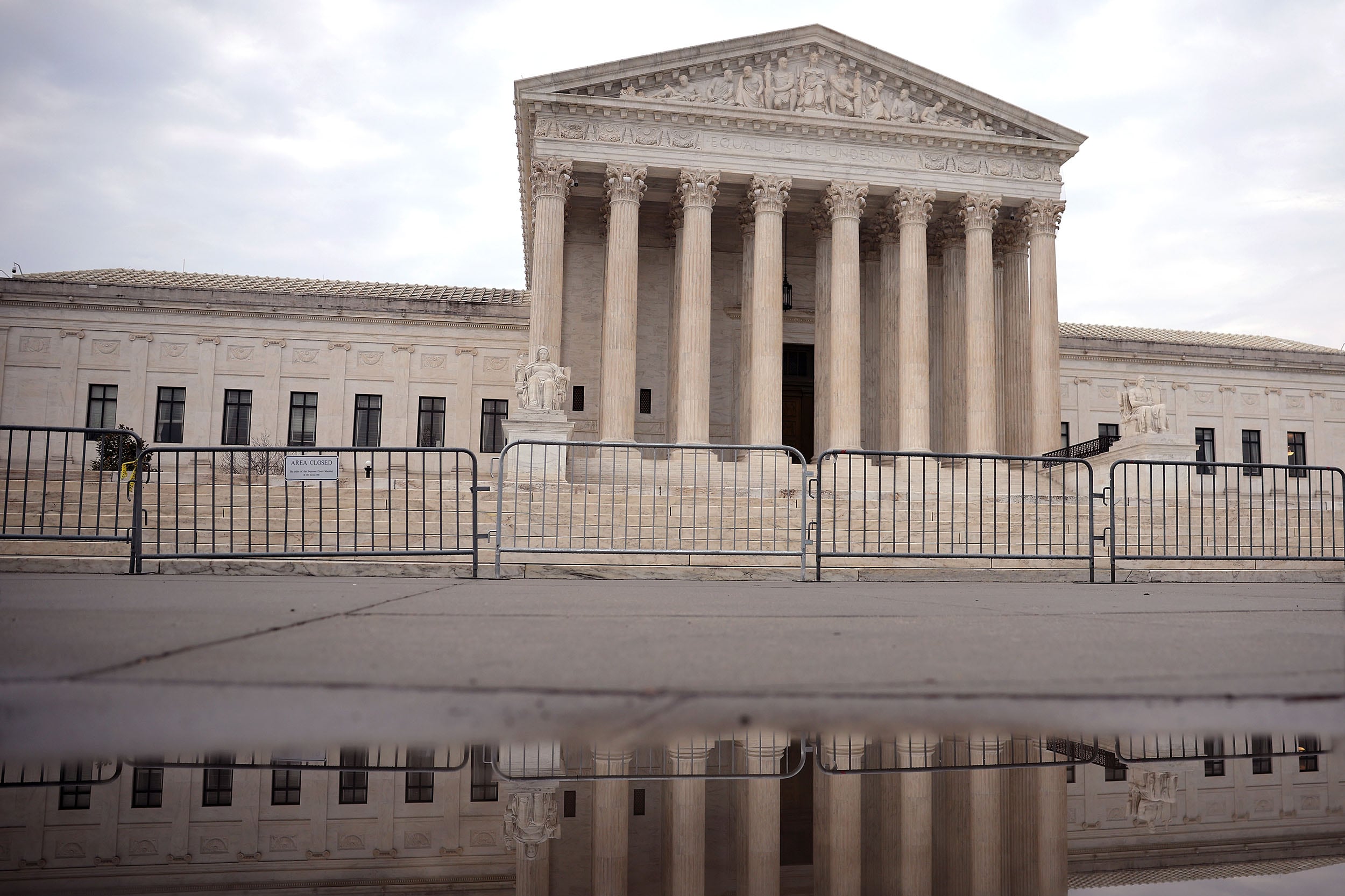 A photograph of the U.S. Supreme Court building on a rainy, cloudy day.