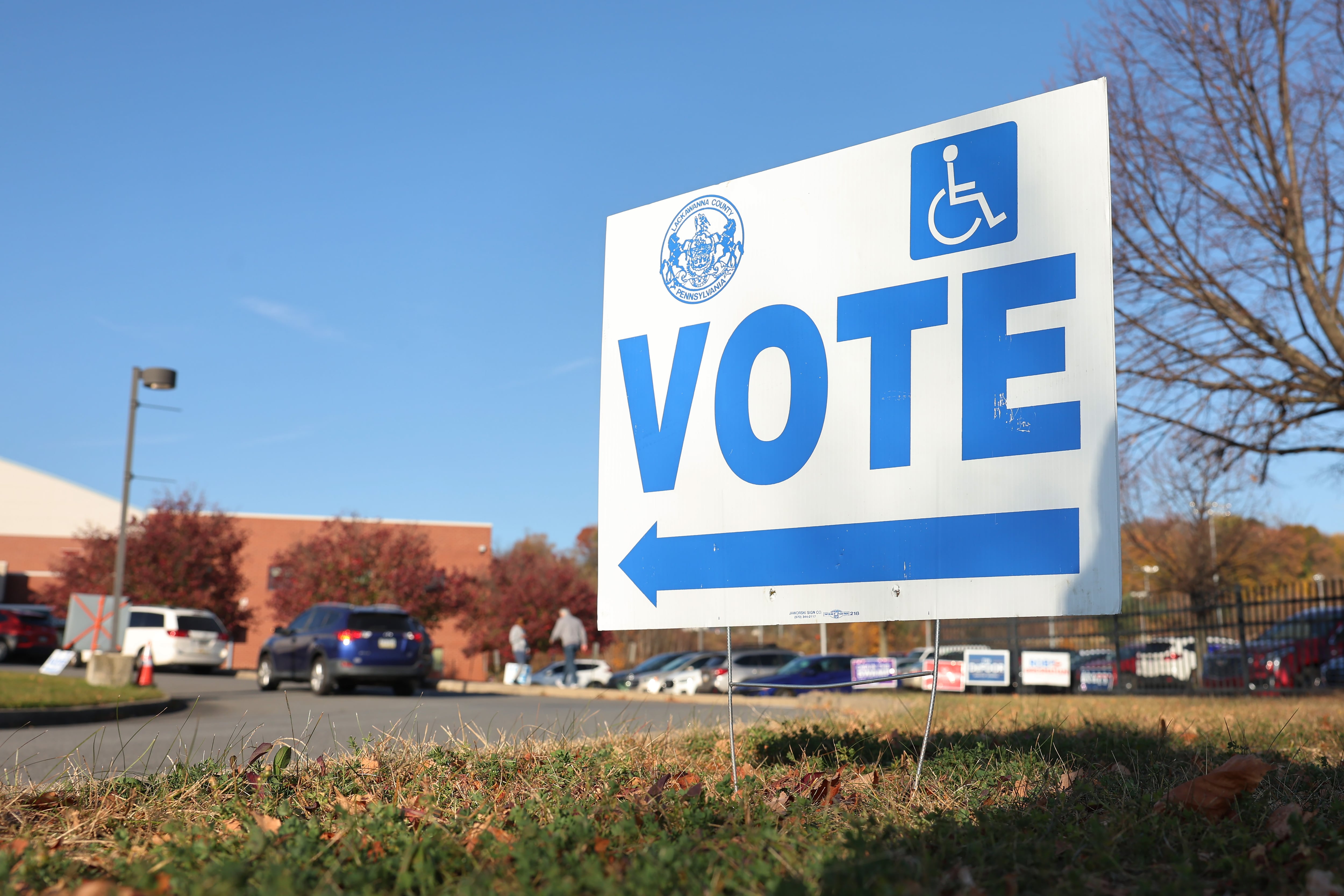 A vote sign points to a building.