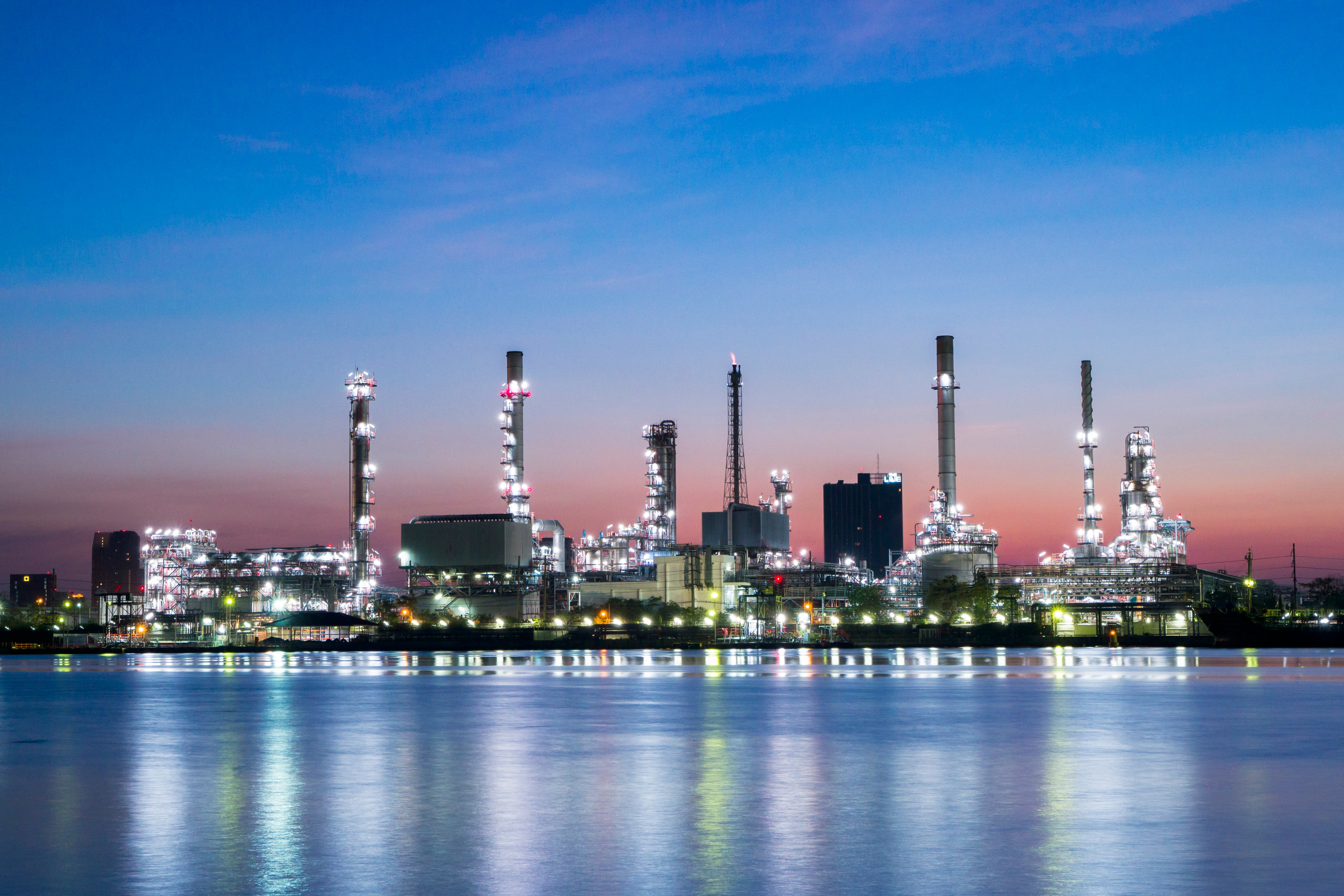 A nighttime view of a chemical plant along the water.