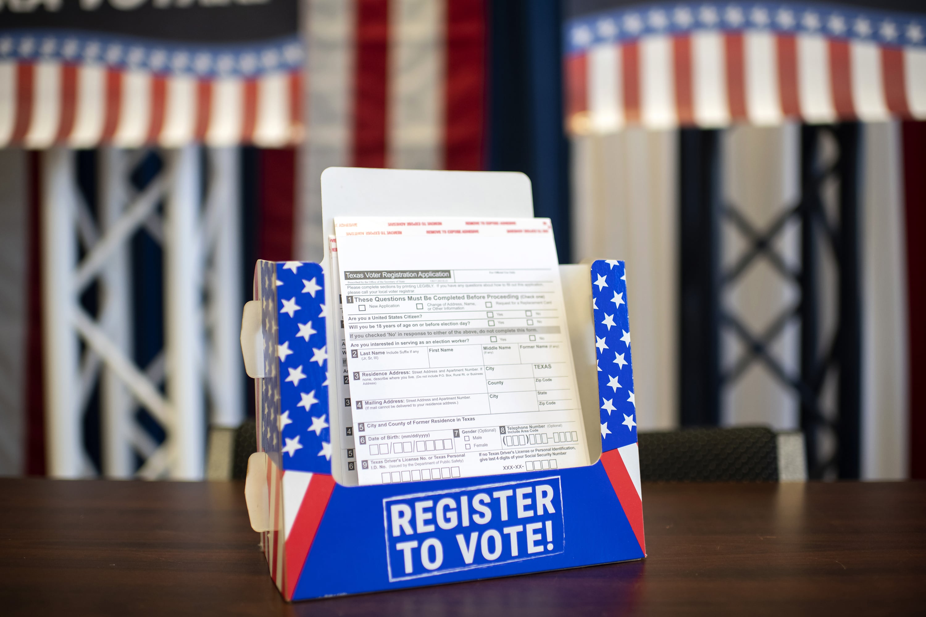 A red, white and blue cardboard box with white paper sits on a table.