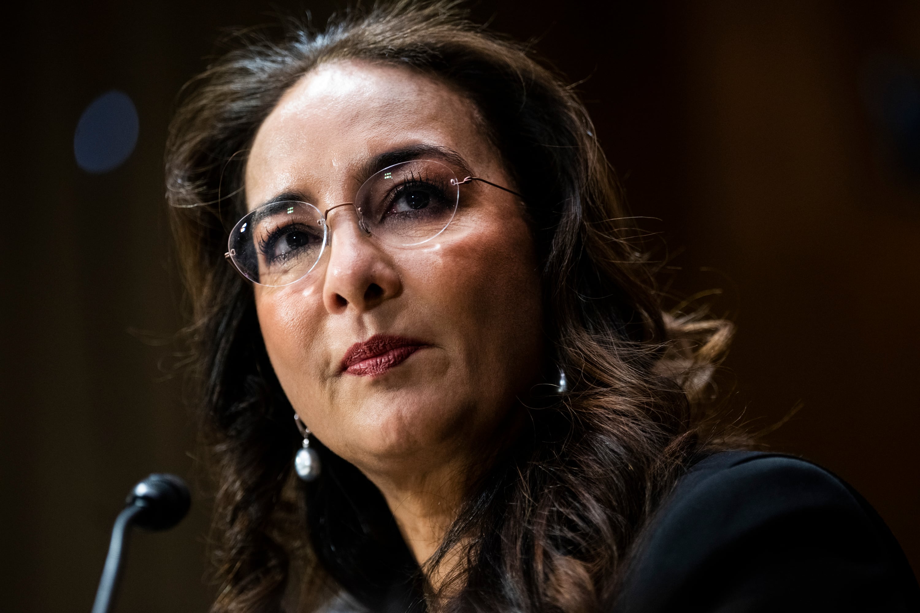 A woman wearing a pair of glasses with a microphone next to her.