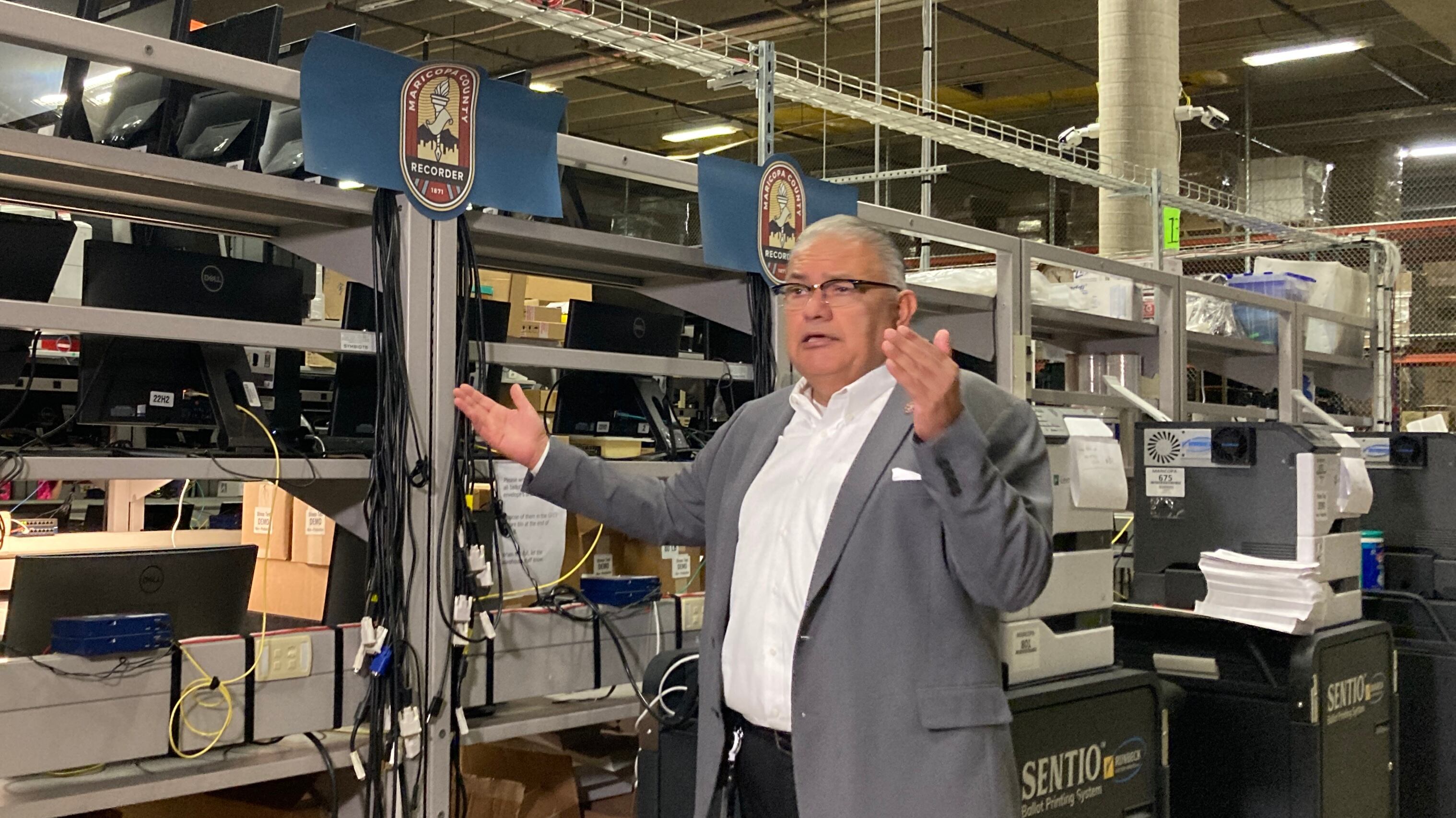 man in suit raises hands in warehouse