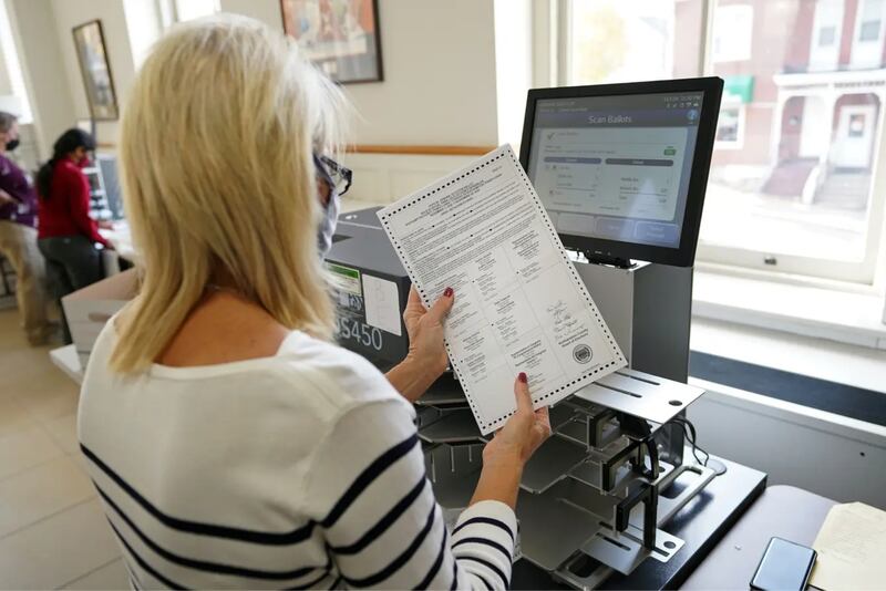 A woman holds a mail ballot in an office in Pennsylvania.